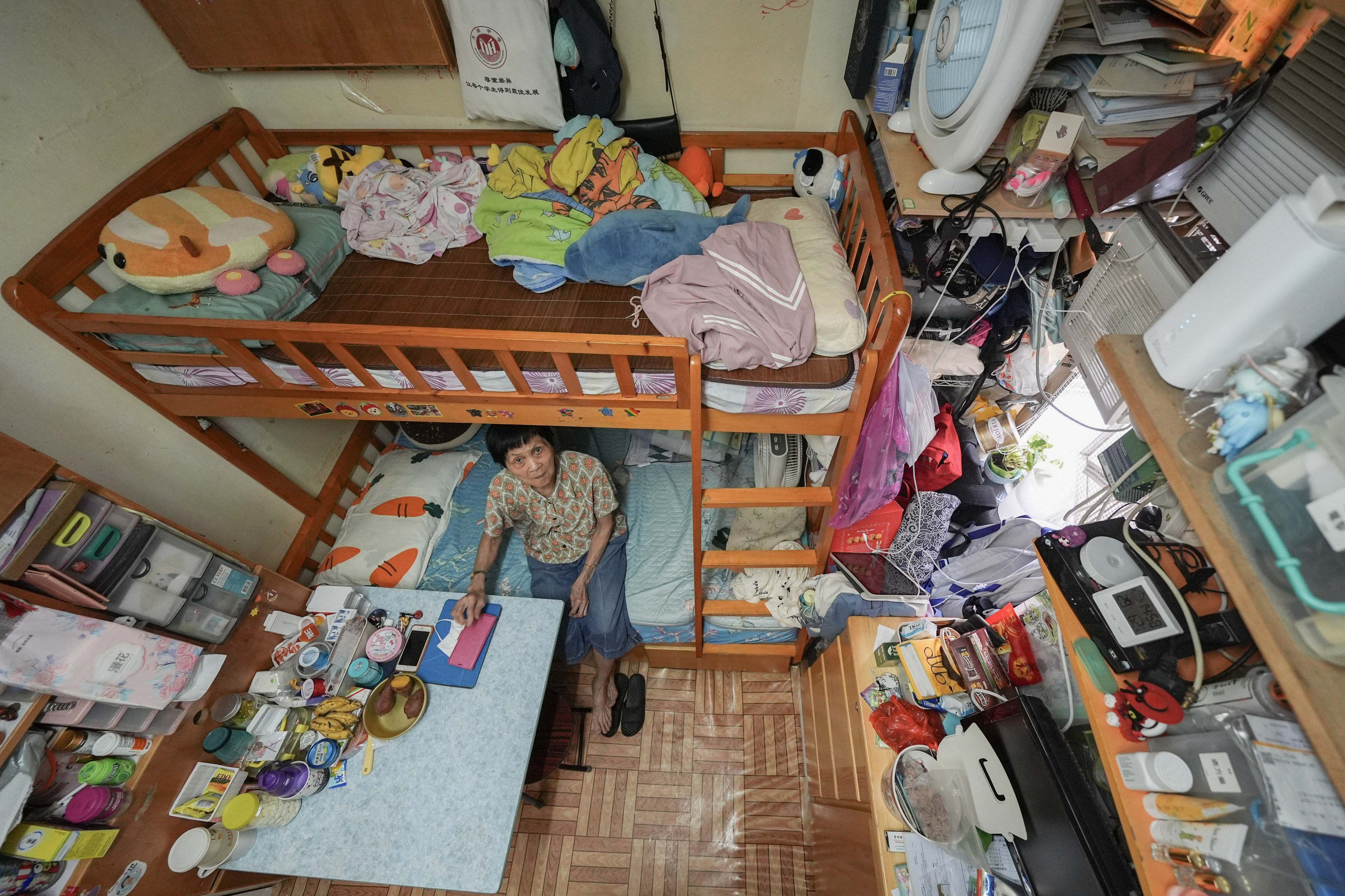 Huang Chaixiang, 79, poses for a photo at her subdivided flat in Sham Shui Po. Chief Executive John Lee Ka-chiu said in his policy address that a new law would ensure subdivided flats met new requirements, including having proper windows, at least one toilet per unit and a minimum size of 86 sq ft. Photo: Eugene Lee