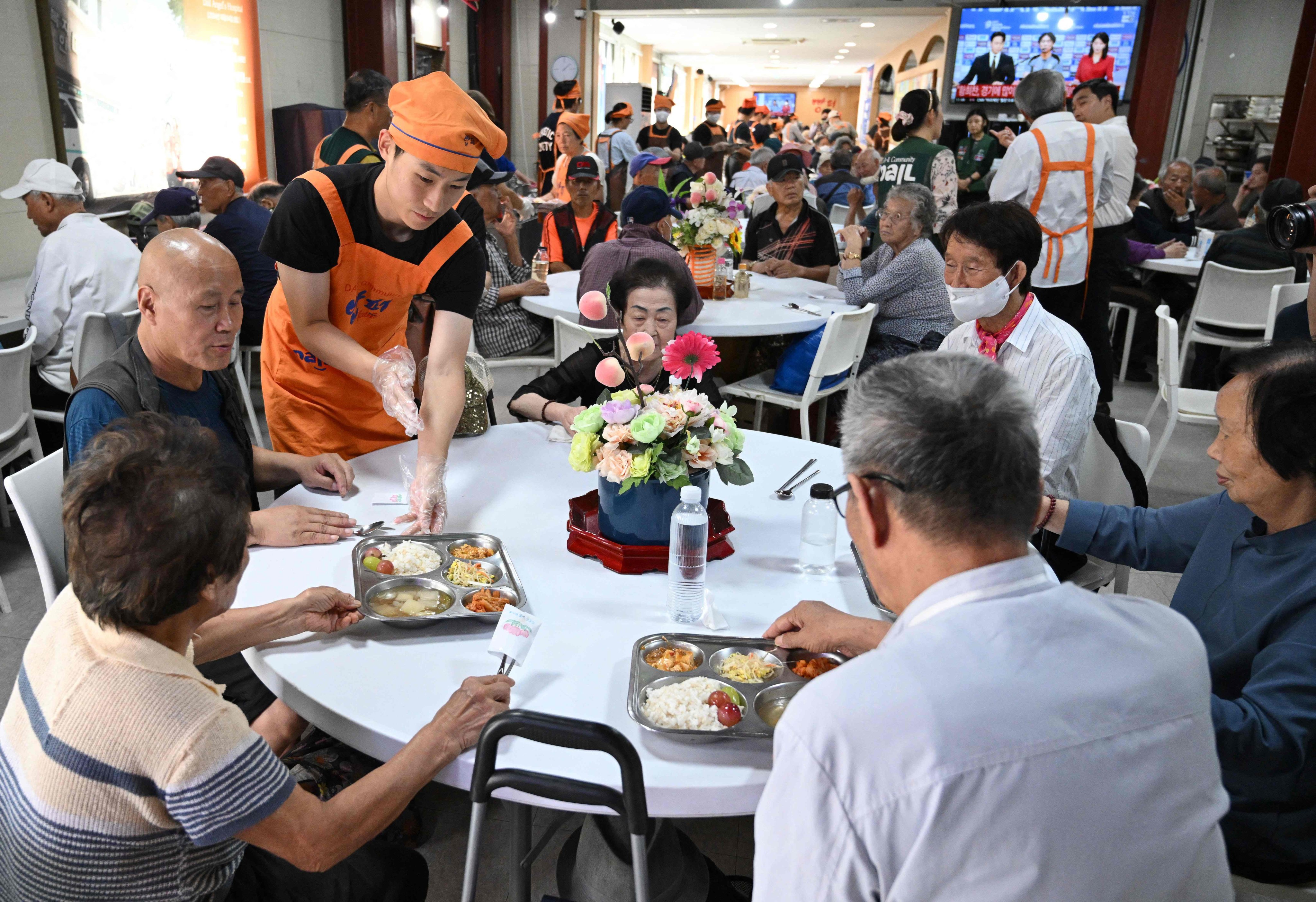 Volunteers serve free hot meals at the “Babfor” service centre in Seoul. Photo: AFP