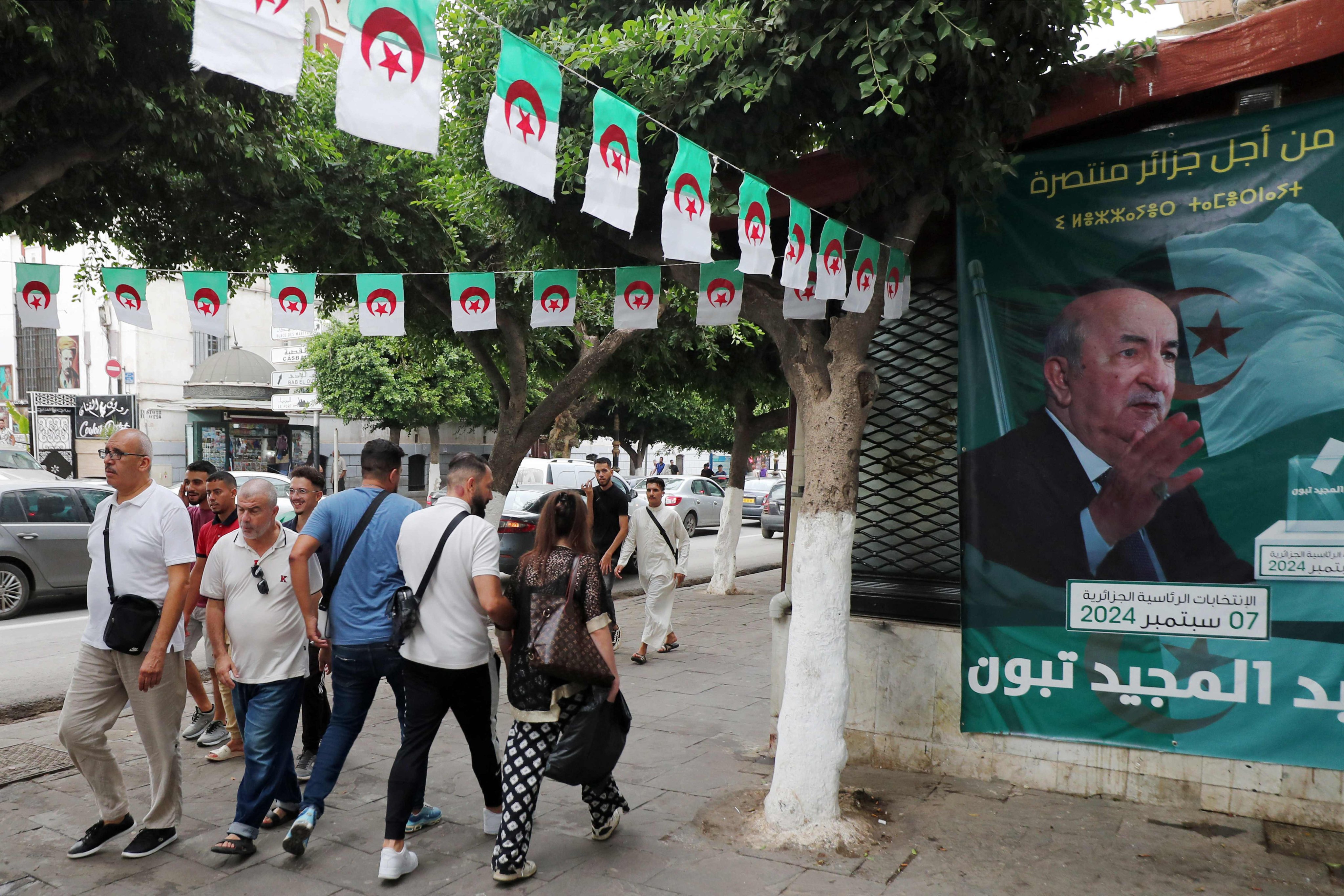 People walk past posters of Algeria’s President Abdelmajid Tebboune in Algiers. The attack came as Algeria has been striving to promote tourism, especially in the Sahara region, with authorities promising to facilitate tourist visas. Photo: AFP