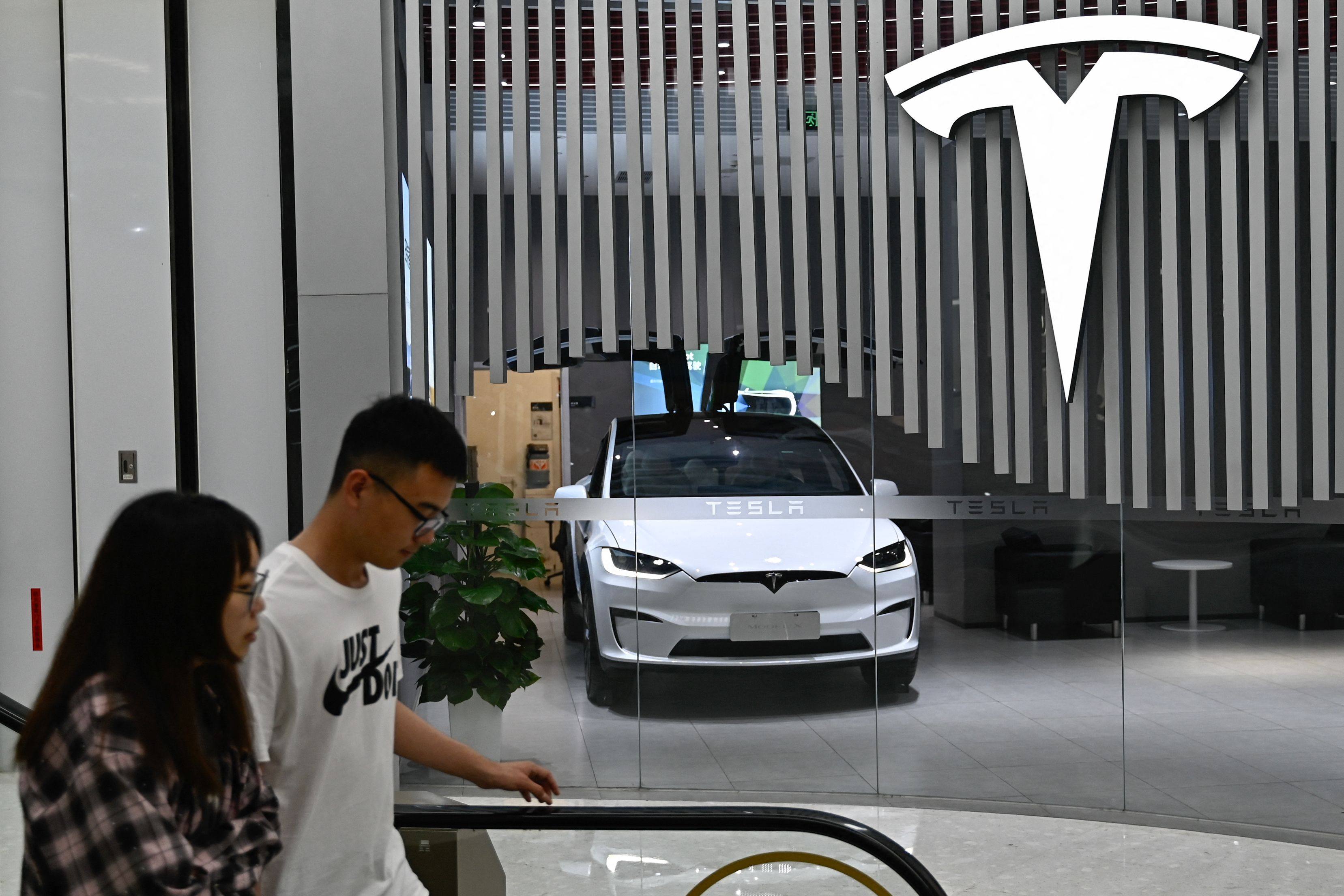 People passed a Tesla shop in Beijing. Photo: AFP 