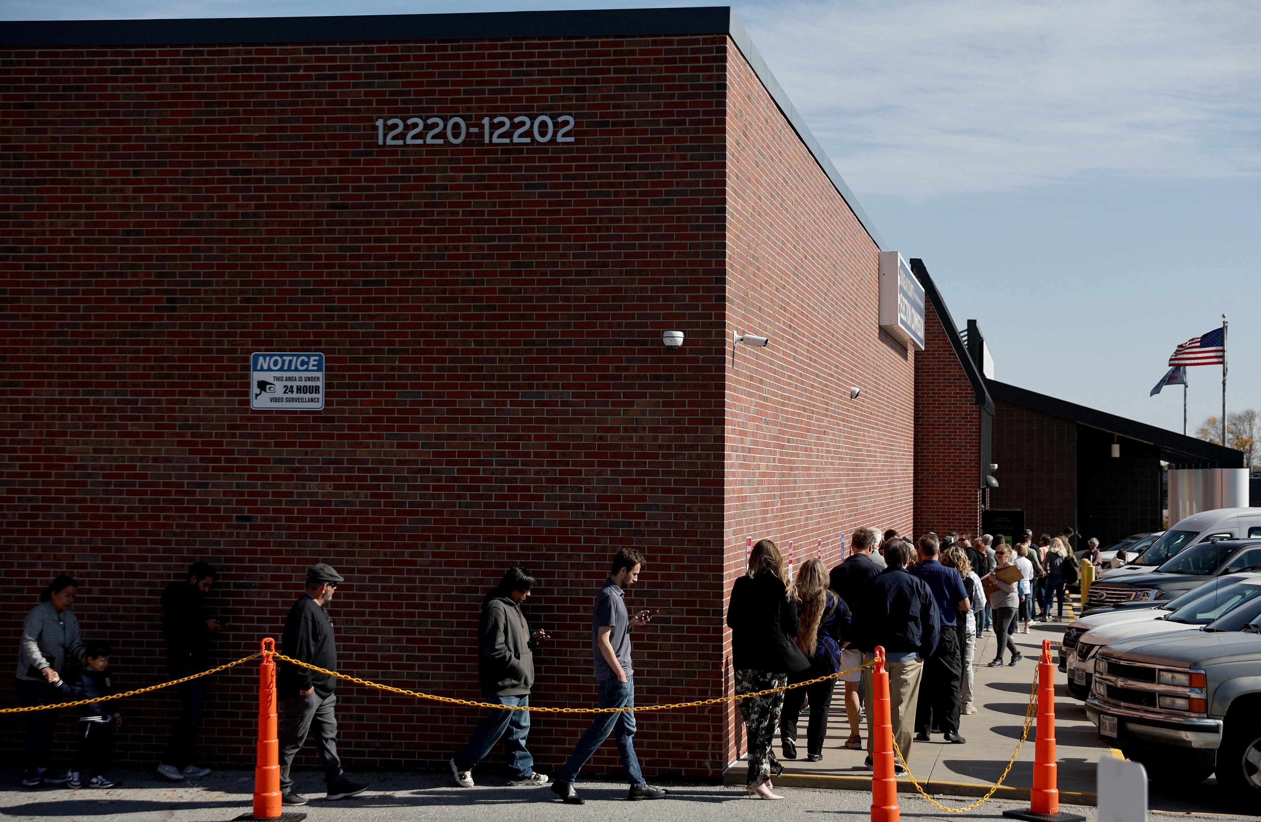 People wait in line to cast early ballots or register to vote outside the Douglas County Election Commission on October 24 in Omaha, Nebraska. Photo: AFP 