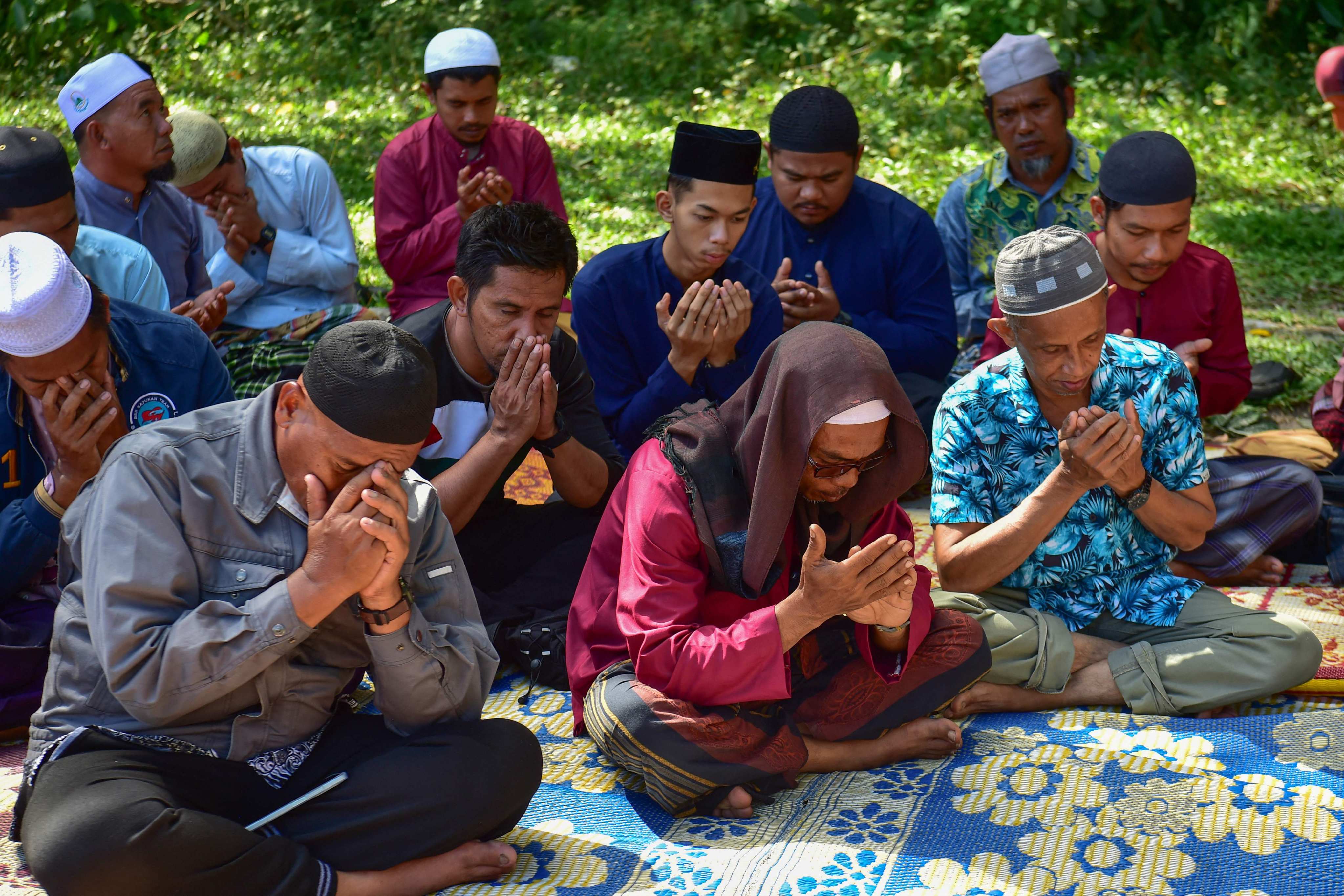 Communities members pray in front of a mass grave for victims of the October 2004 incident known as the “Tak Bai massacre” when scores of Muslim protesters suffocated in Thai army trucks, at a cemetery in Thailand’s southern province of Narathiwat on October 25. Photo: AFP