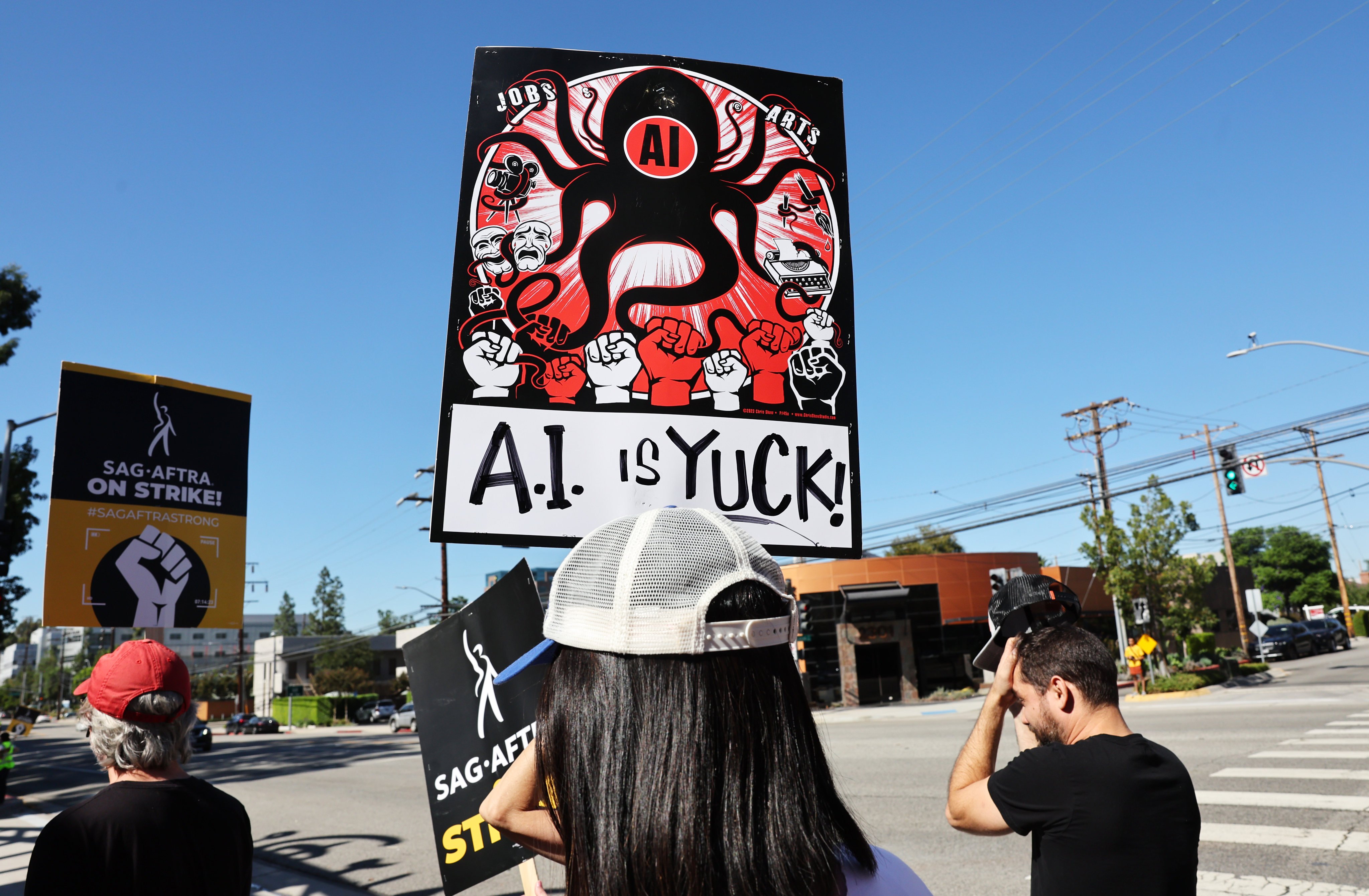 A sign refers to people’s distrust of AI as striking SAG-AFTRA members and supporters picket outside Disney Studios in October 2023, in Burbank, California. Artificial intelligence is not yet being used to help make movies in Hollywood. Photo: Getty Images