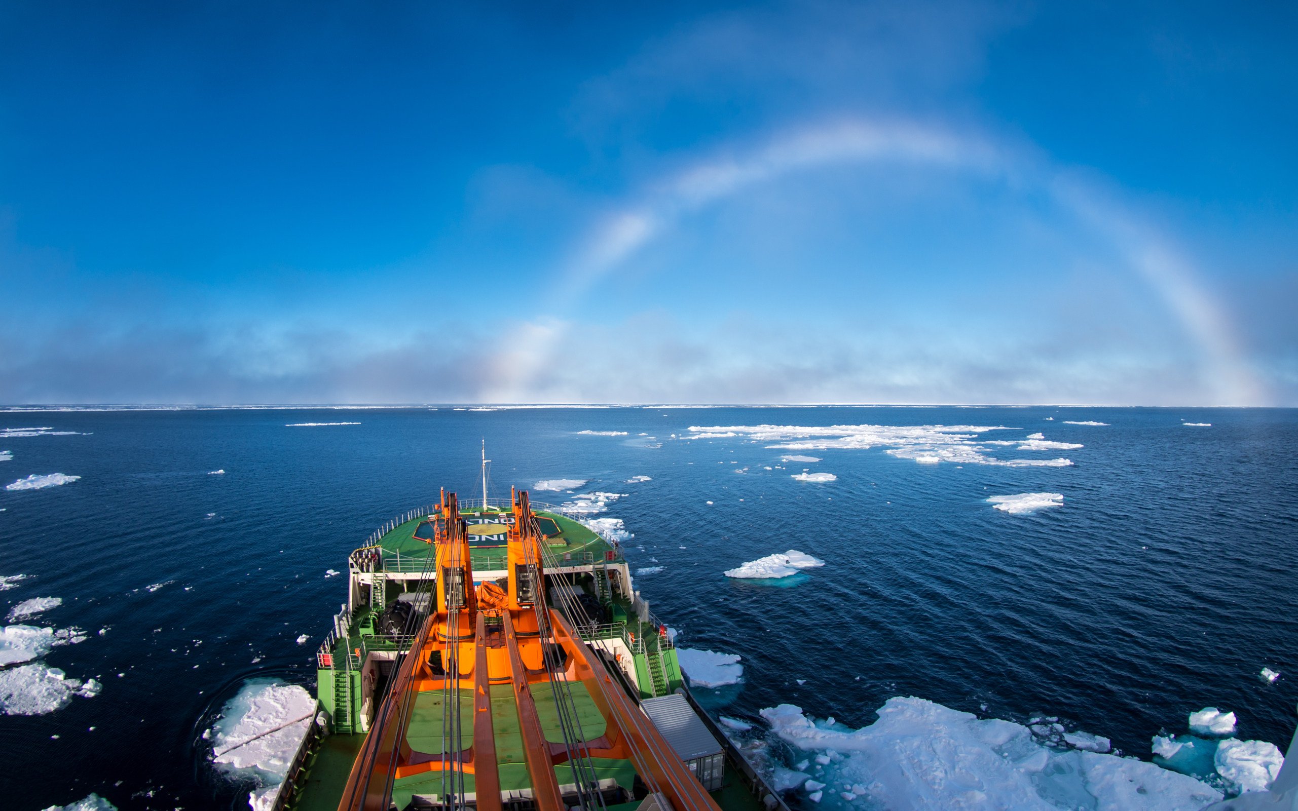 A research ship passes a white rainbow in the ice-strewn East-Siberian Sea off the Arctic Ocean. Photo: Shutterstock