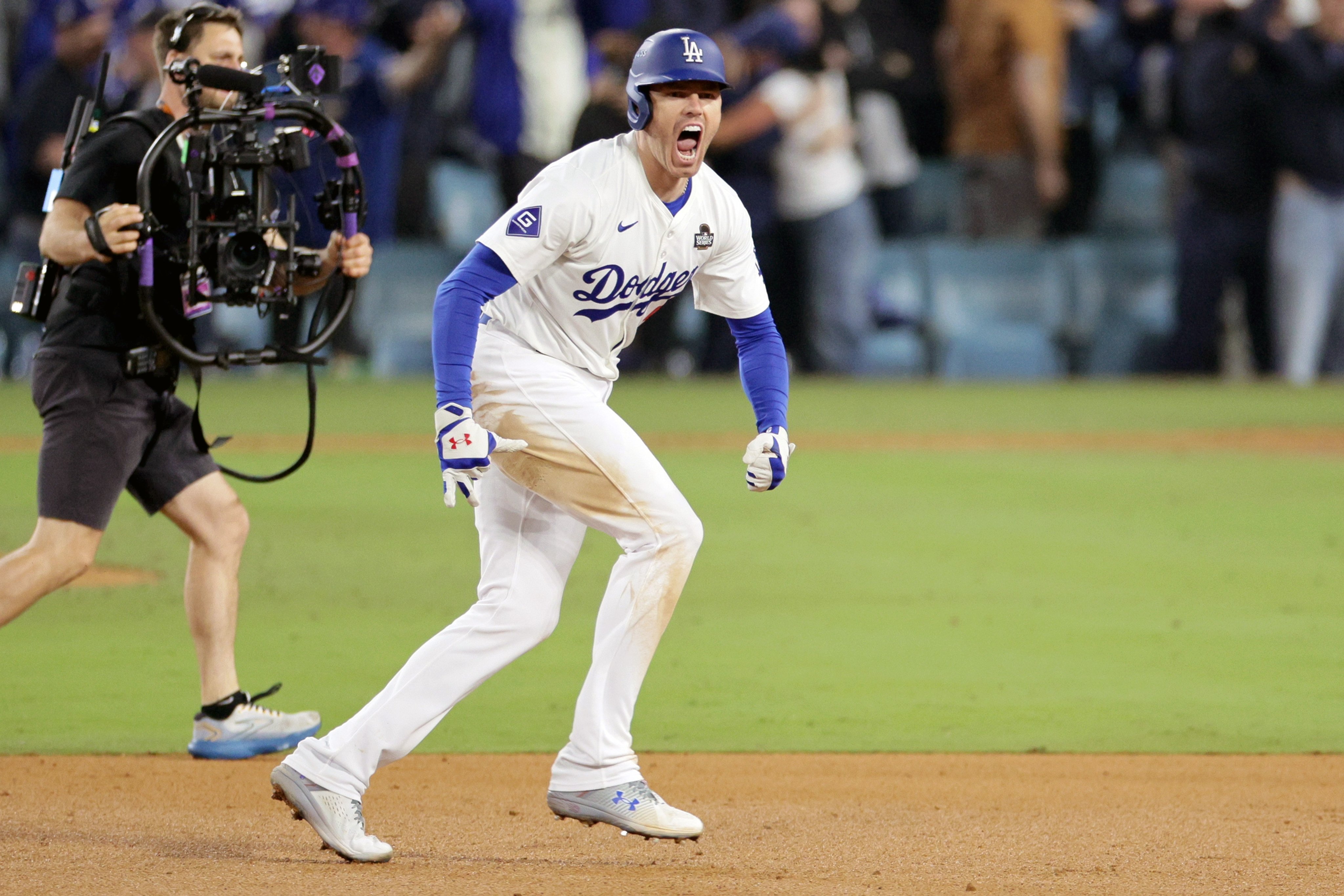 The Los Angeles Dodgers’ Freddie Freeman rounds the bases after hitting the game-winning grand slam home run off New York Yankees relief pitcher Nestor Cortes in the tenth inning of World Series game one. Photo: EPA-EFE