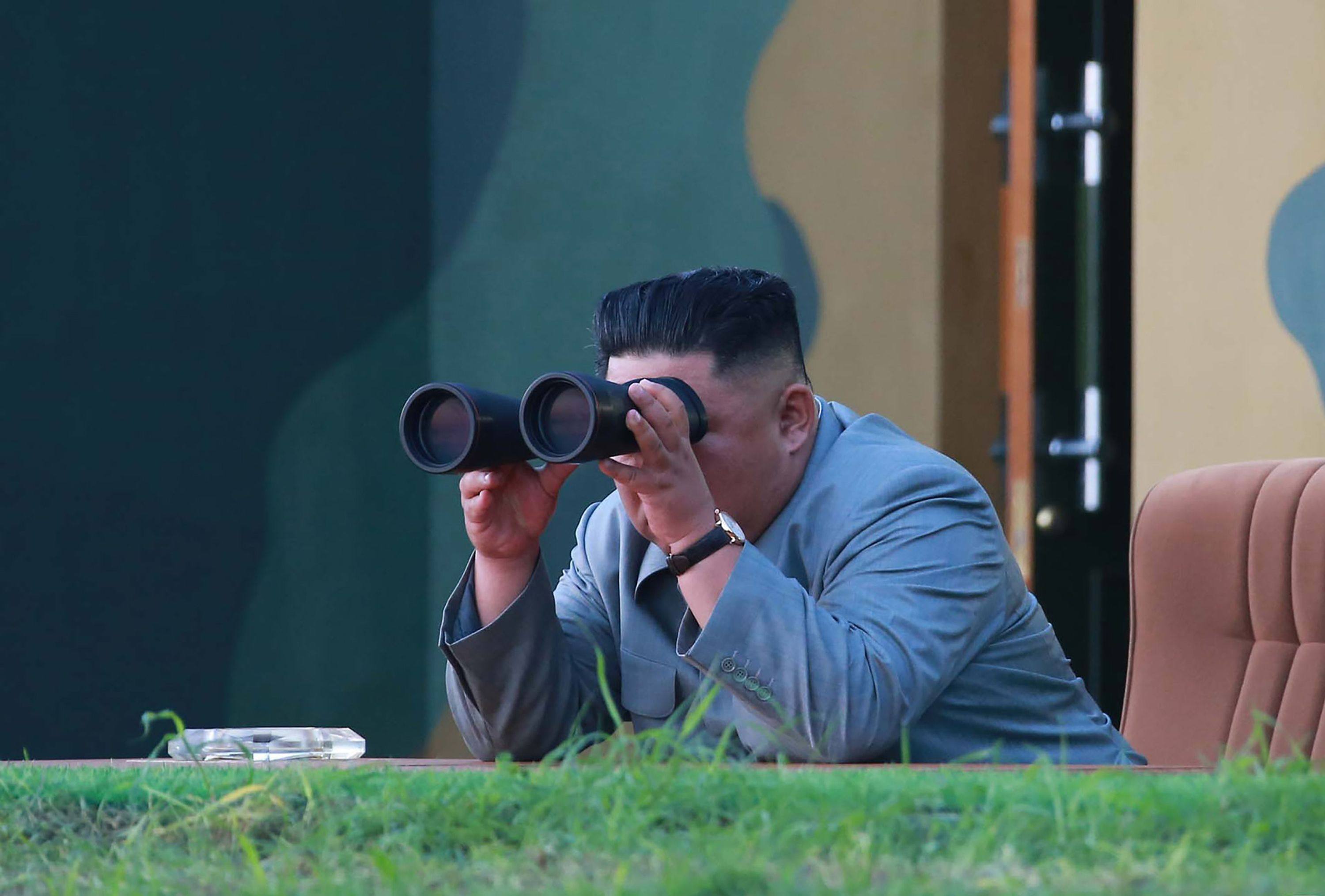 North Korean leader Kim Jong-un watches a missile test through binoculars at an undisclosed location. Photo: KCNA via KNS / AFP