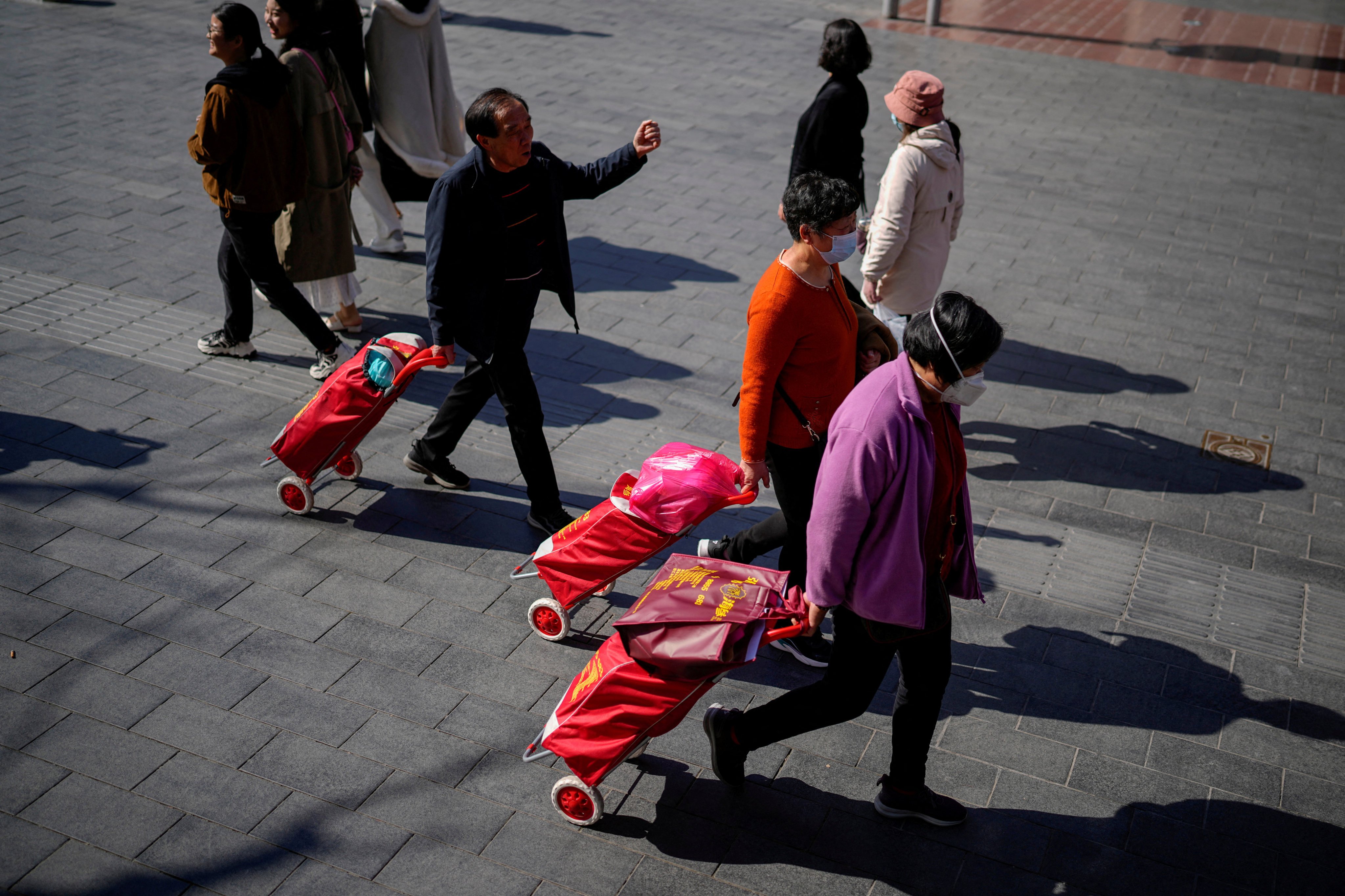 People walk with their shopping trolleys at the main shopping area in Shanghai. Photo: Reuters