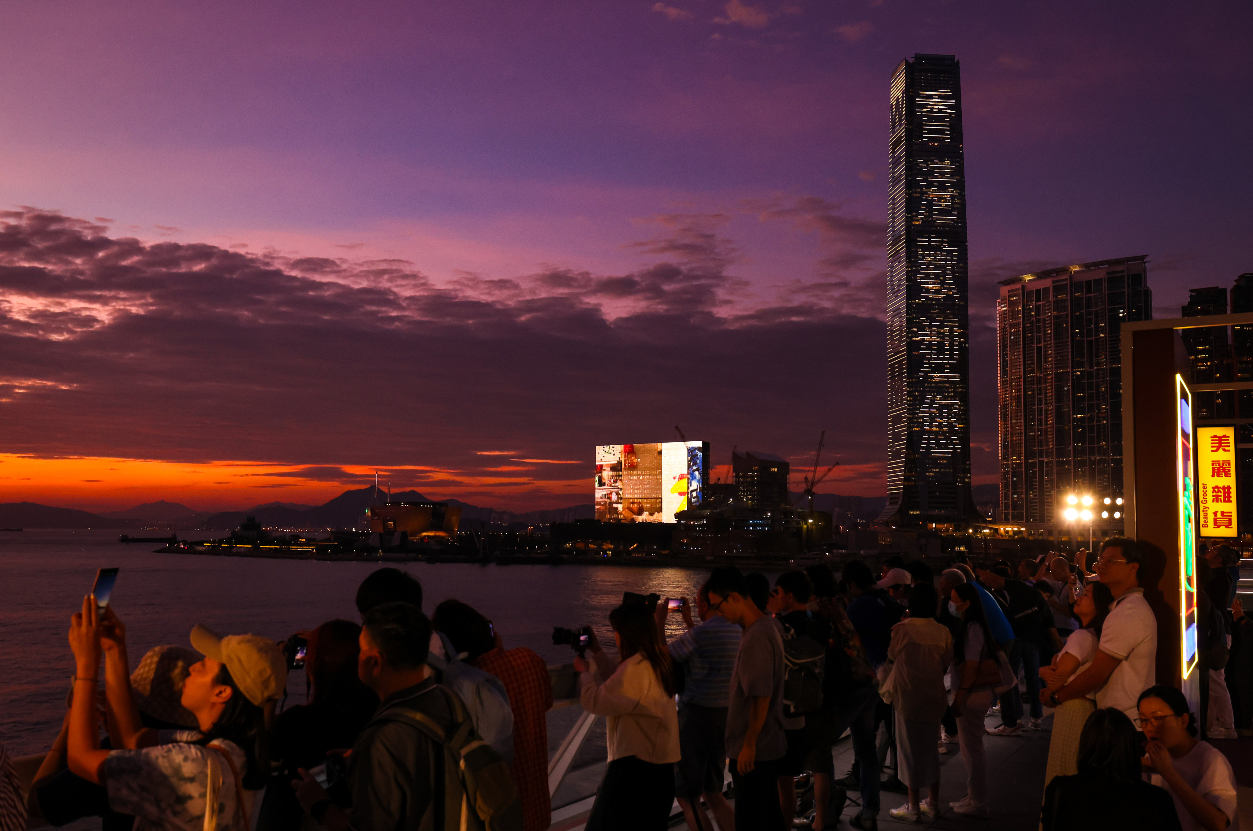 People take in the sunset view from Tsim Sha Tsui promenade. Photo: Nora Tam