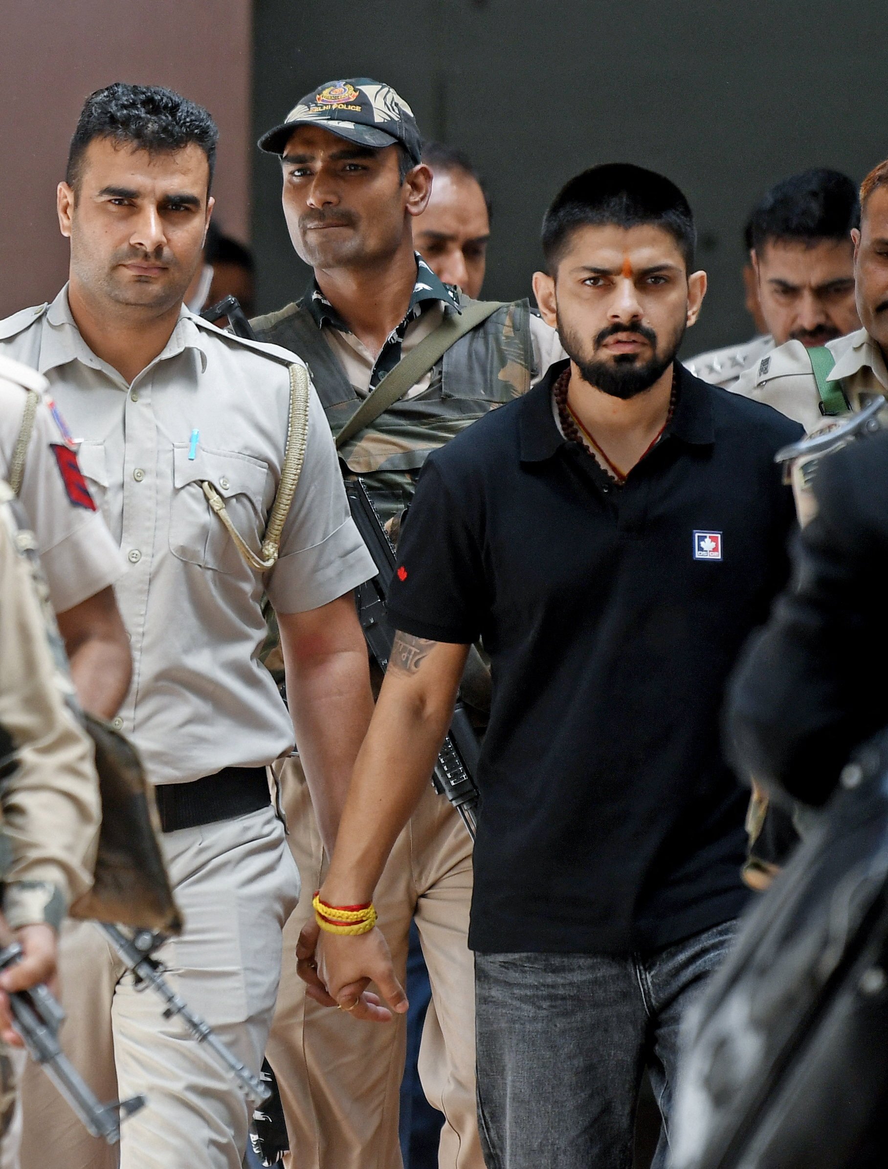 Policemen escort Lawrence Bishnoi at a court in New Delhi in April 2023. Photo: ANI/Handout via Reuters