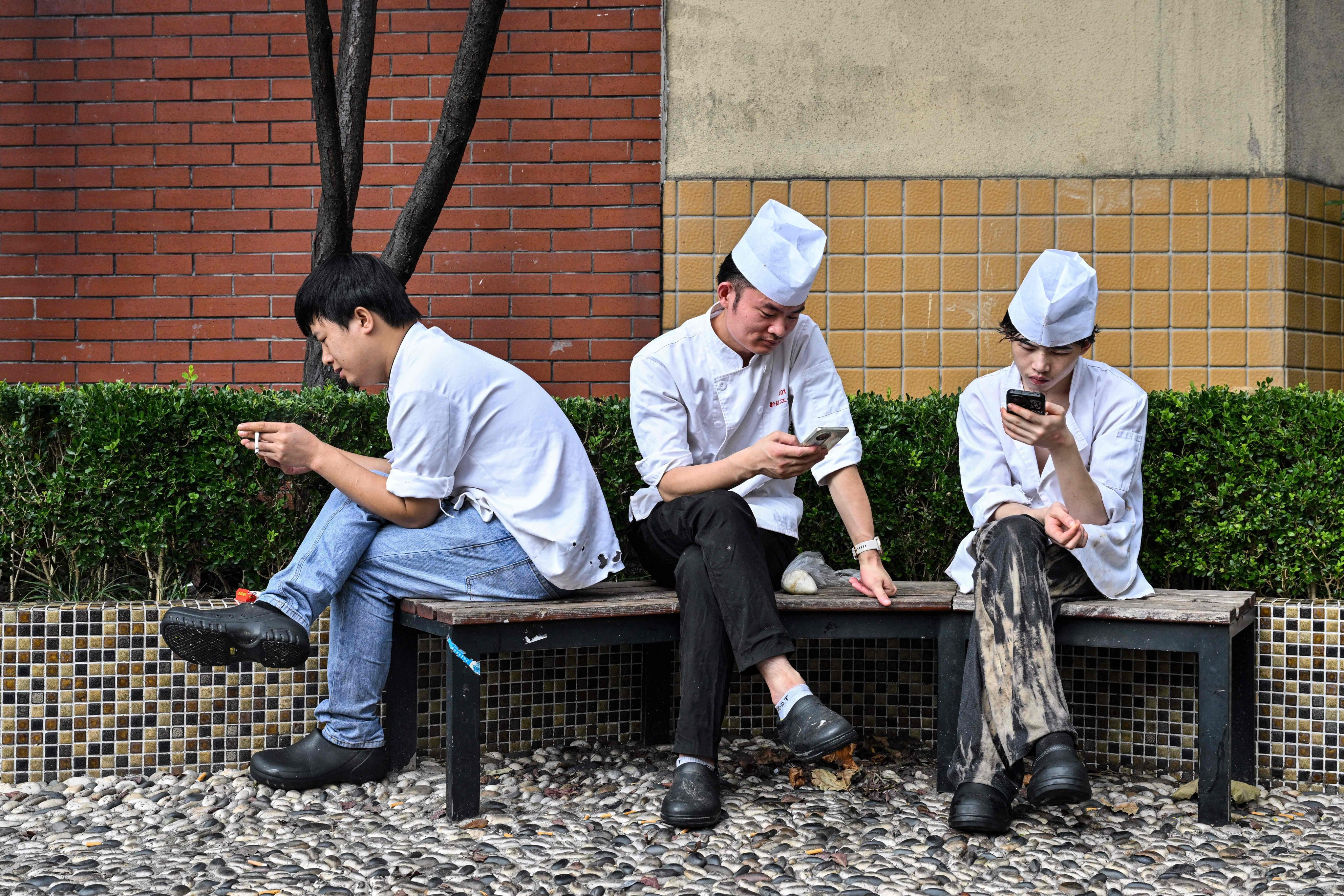 People look at their smartphones outside a restaurant in Shanghai. Photo: AFP