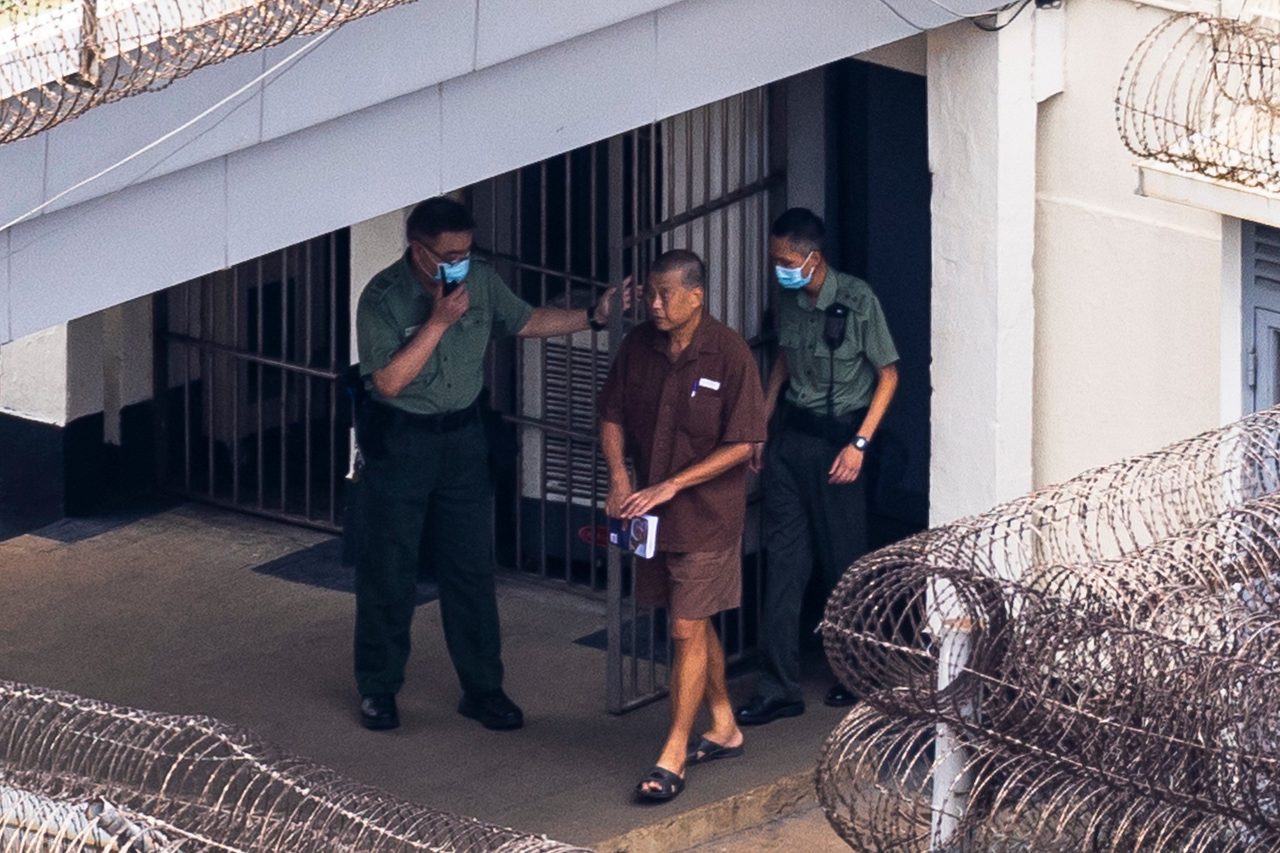 Former tycoon Jimmy Lai is escorted through the grounds of Stanley Prison in July 2023. Photo: Associated Press