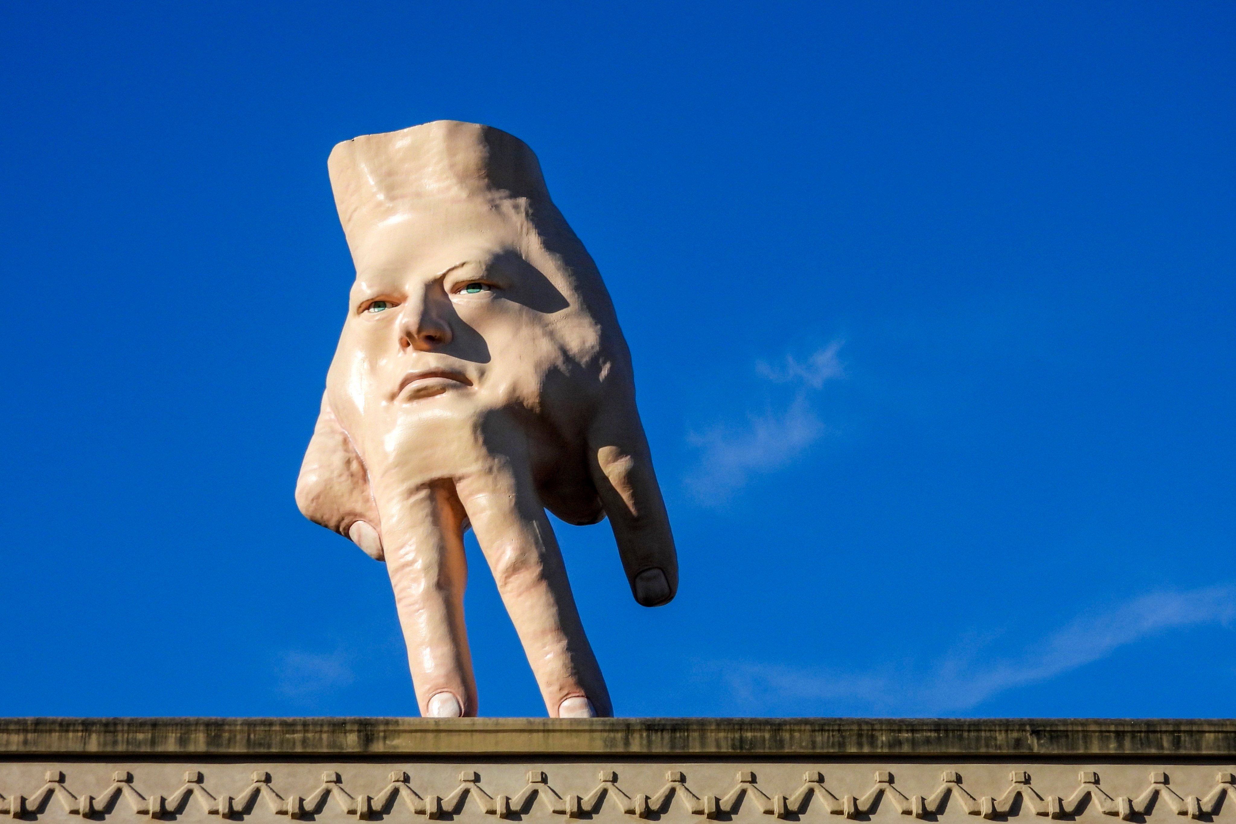 A 16-foot (almost 5 metres) hand sculpture named Quasi stands perched on its fingertips atop the roof of an art gallery in Wellington. Photo: AP