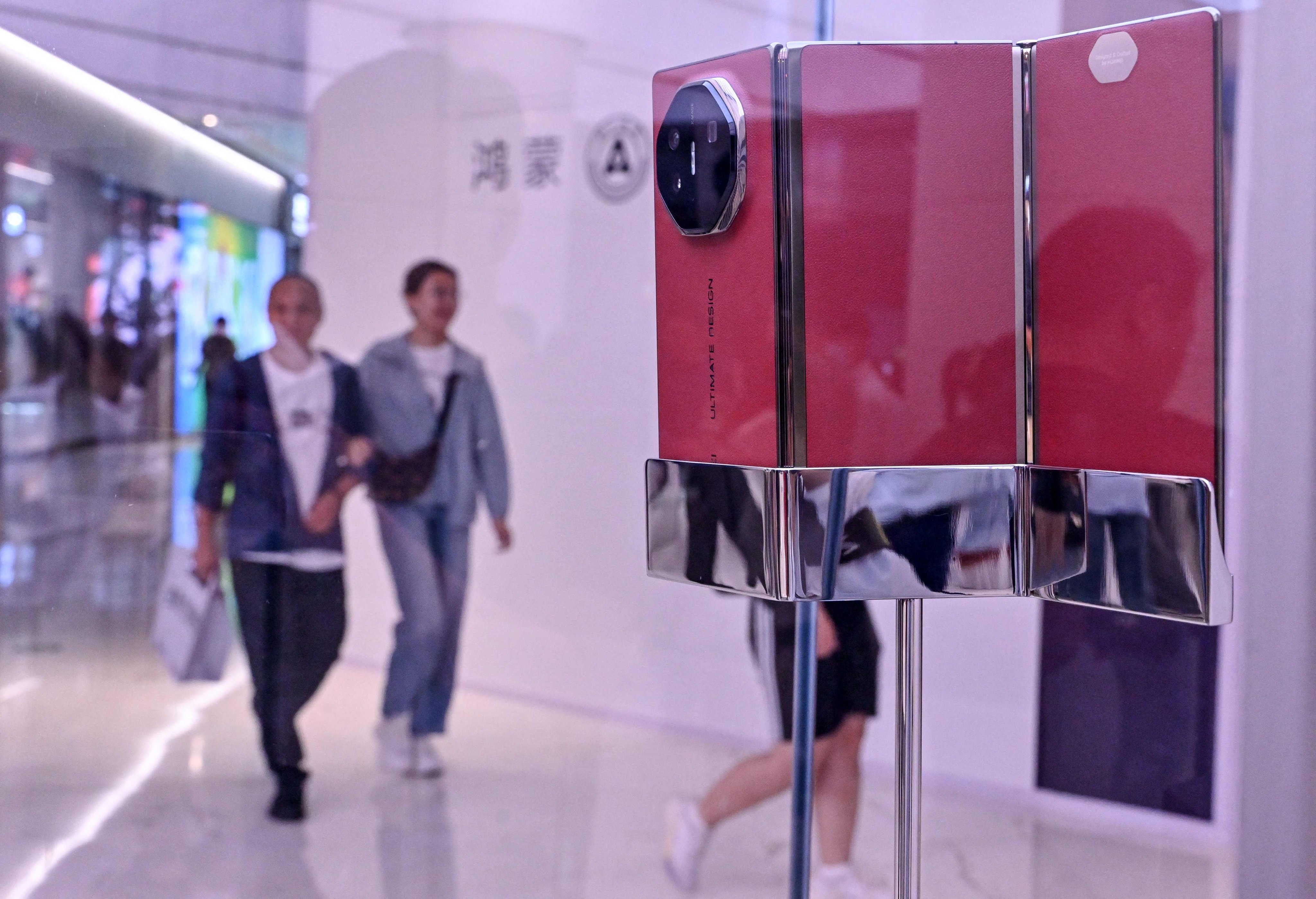 People walk past a Huawei Mate XT triple-folding phone displayed at a Huawei store in Beijing on September 10, 2024. Photo: AFP