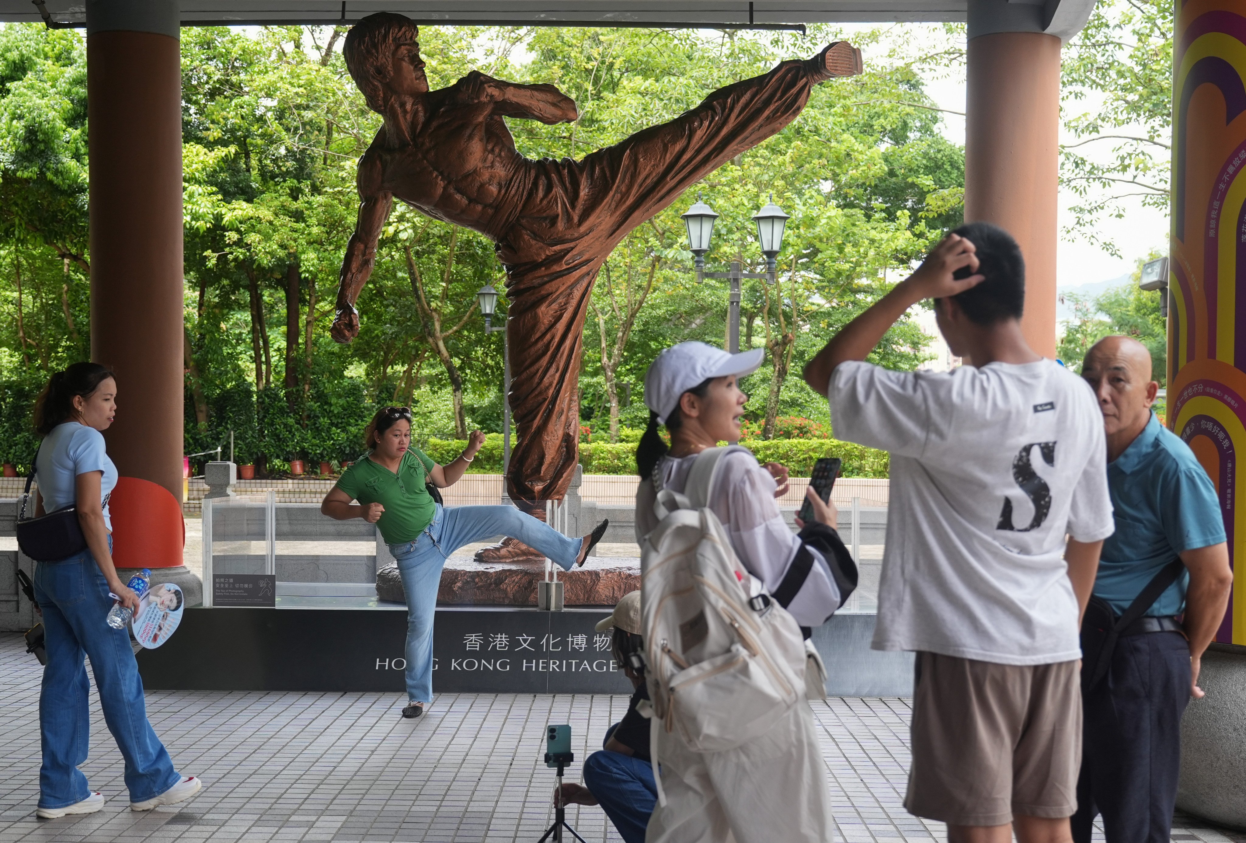 People take selfies with a statue of Bruce Lee at the Hong Kong Heritage Museum in Sha Tin on July 20, the 51st anniversary of his death. Photo: Eugene Lee 