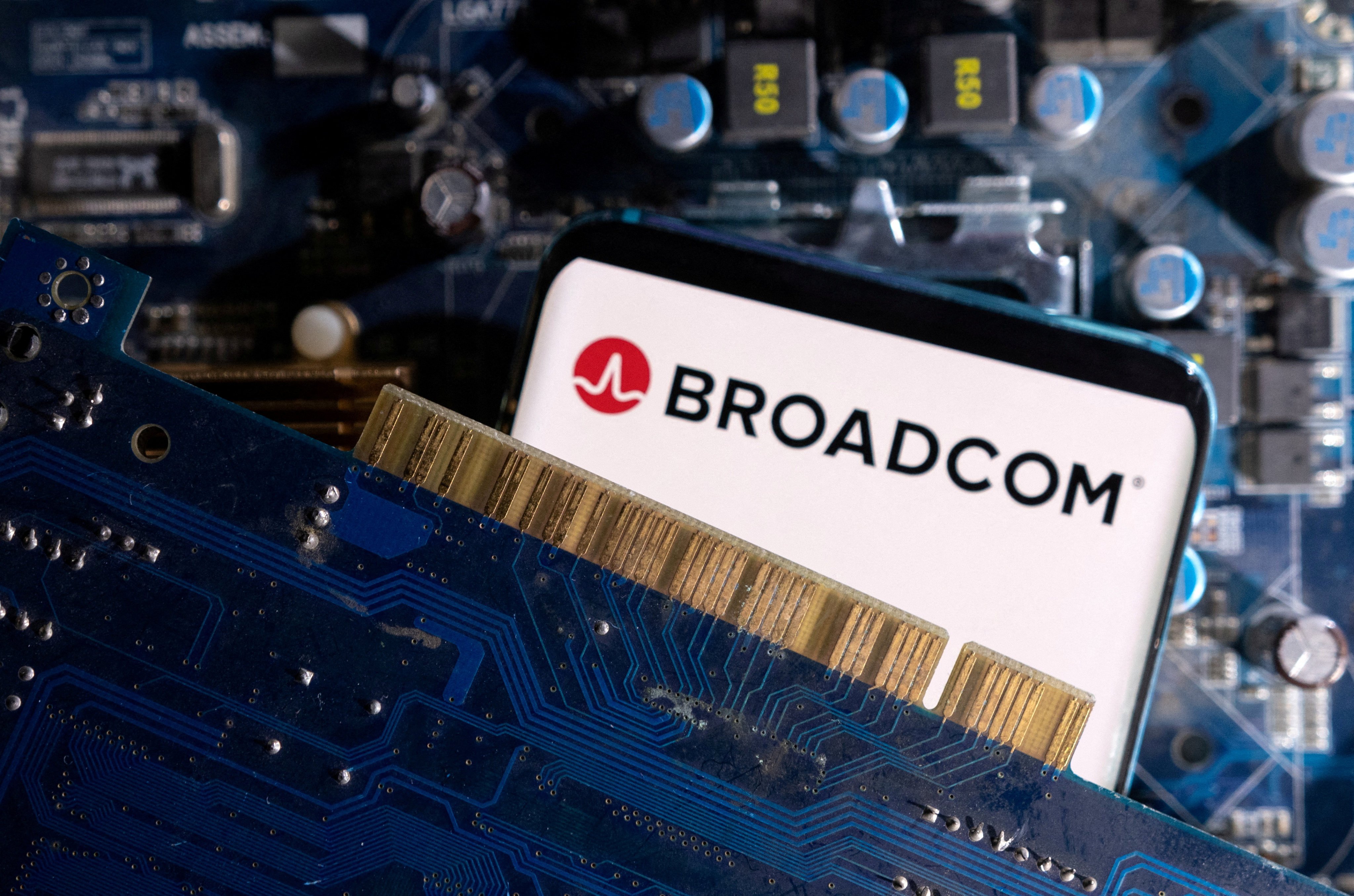 A smartphone with a displayed Broadcom logo is placed on a computer motherboard in this illustration taken March 6, 2023. Photo: Reuters