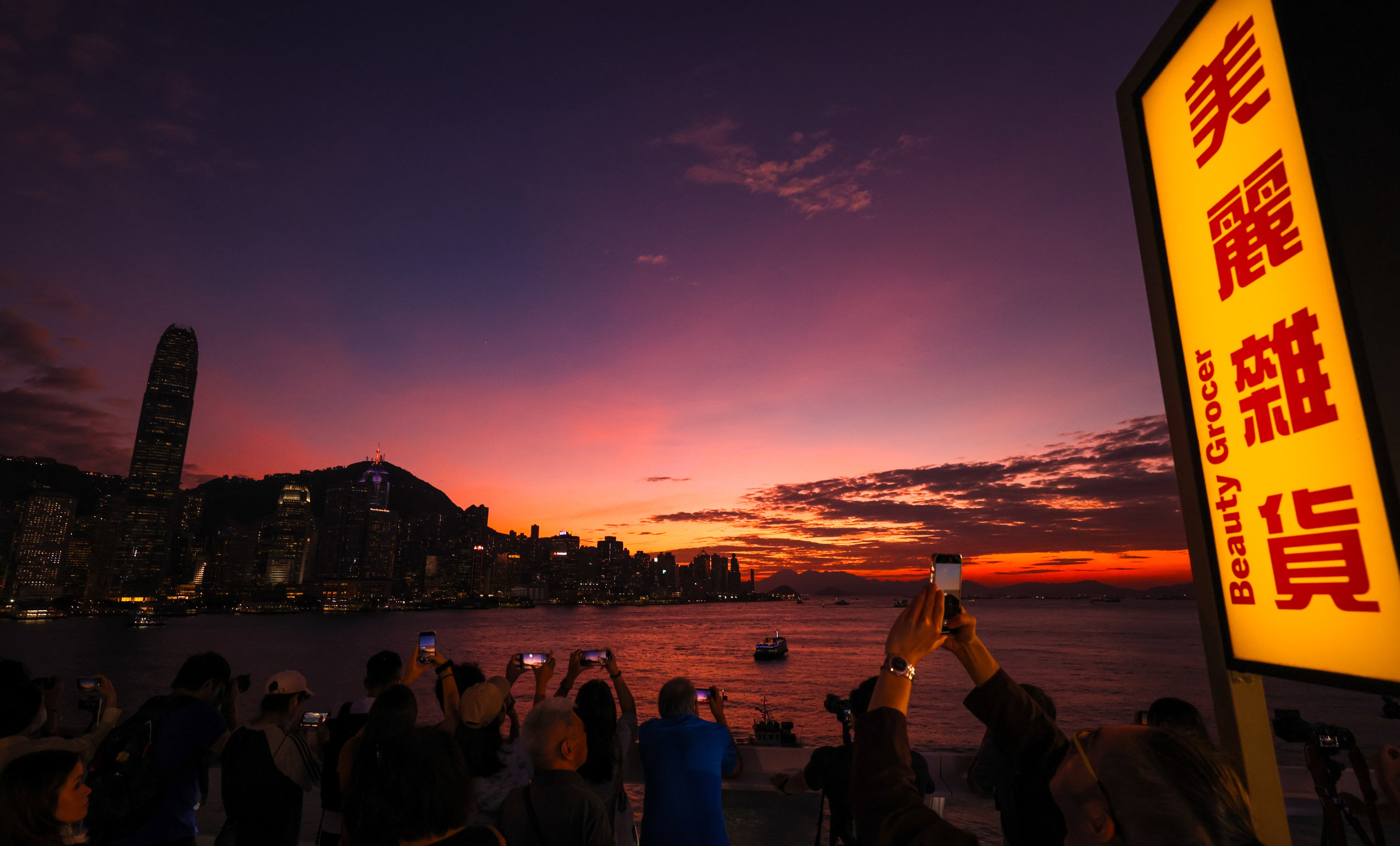 People admire the sunset skyline from the Tsim Sha Tsui promenade as Severe Tropical Storm Trami approaches the city under the No 1 typhoon signal on October 25. Photo: Nora Tam