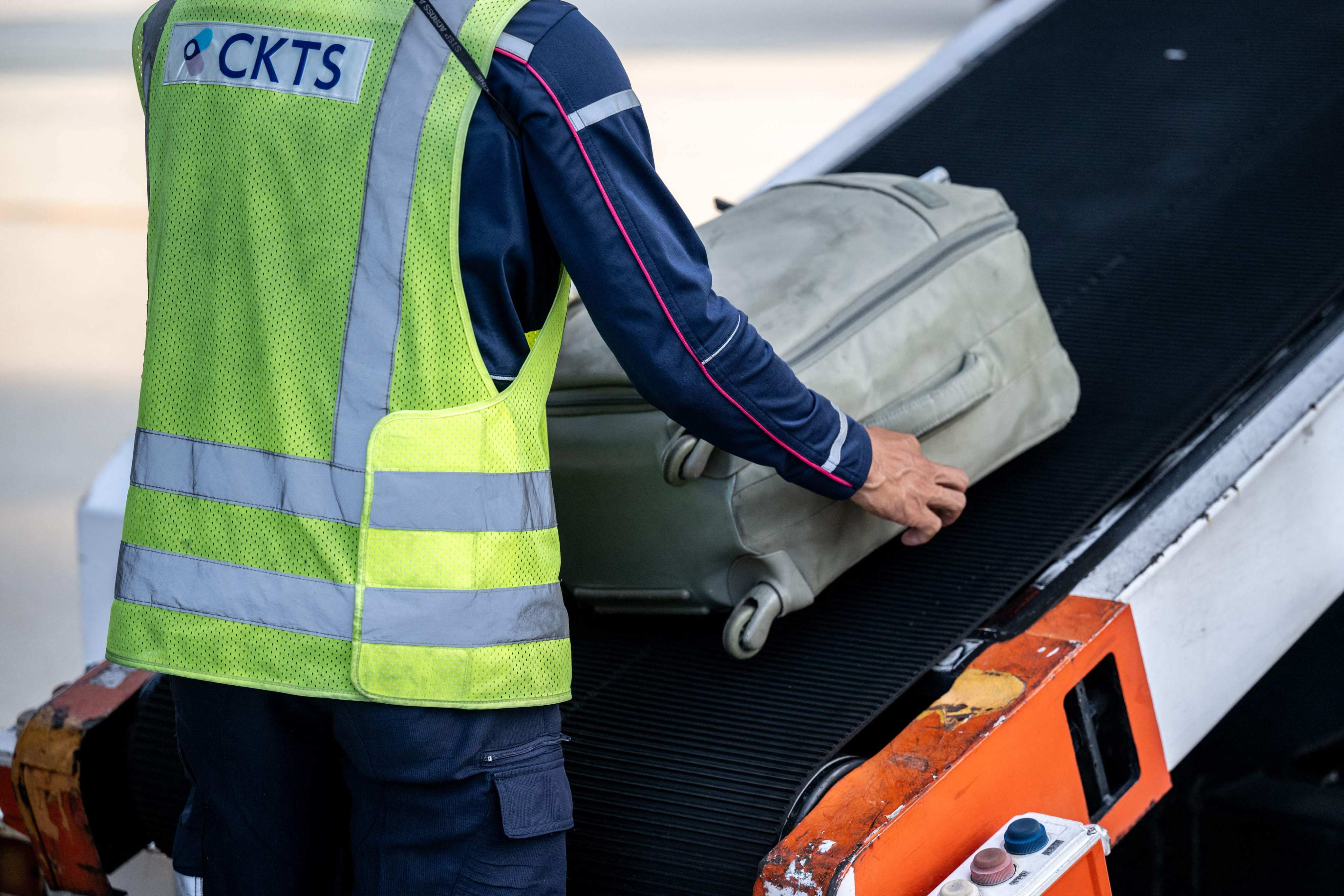 A staff member transfers baggages into a Cathay Pacific flight for departure in Kansai International Airport of Osaka Prefecture. Photo: AFP