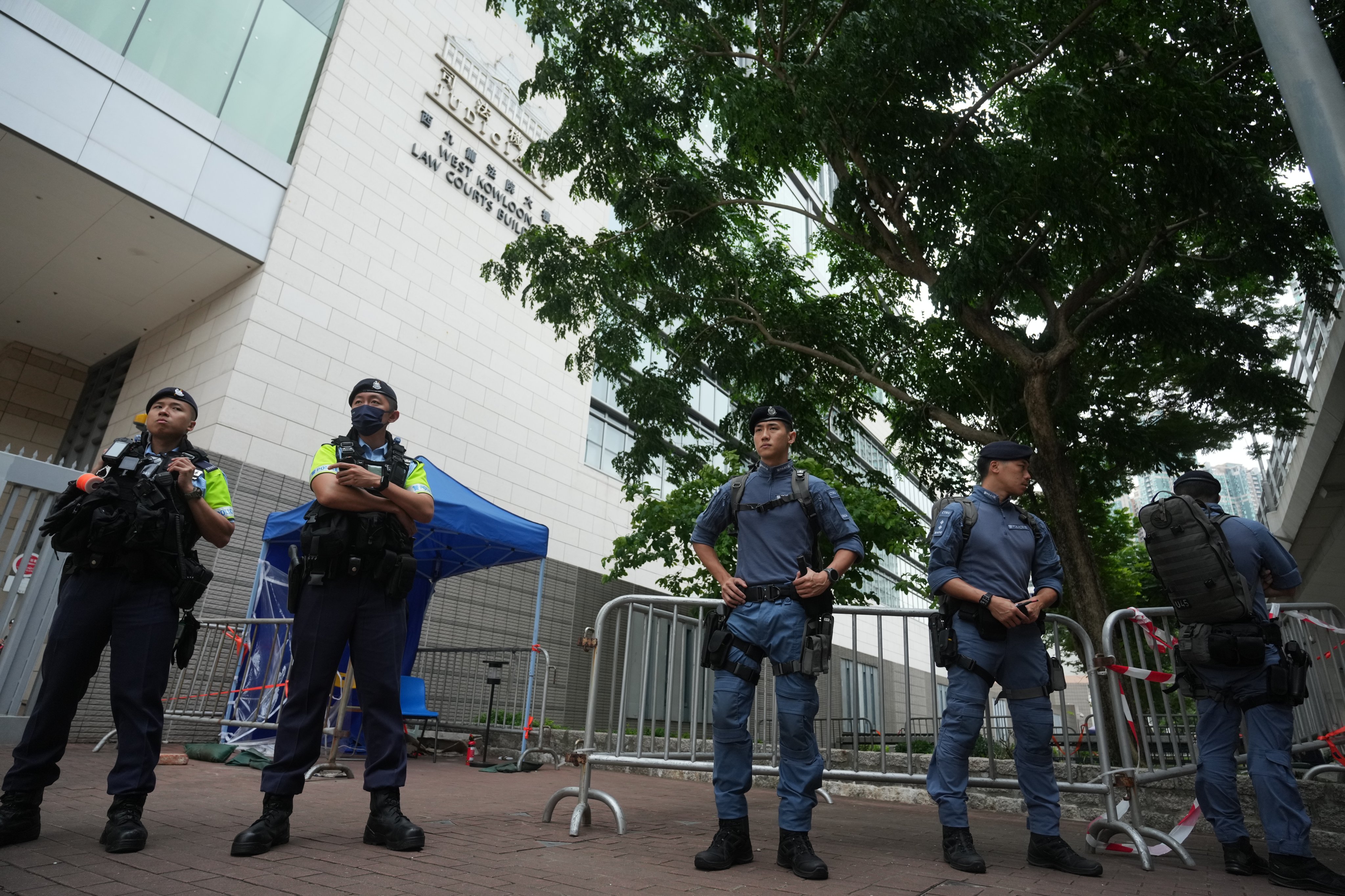 Police officers stand guard outside the West Kowloon magistrates’ courts during a hearing of a national security case on May 30. Photo: Sam Tsang