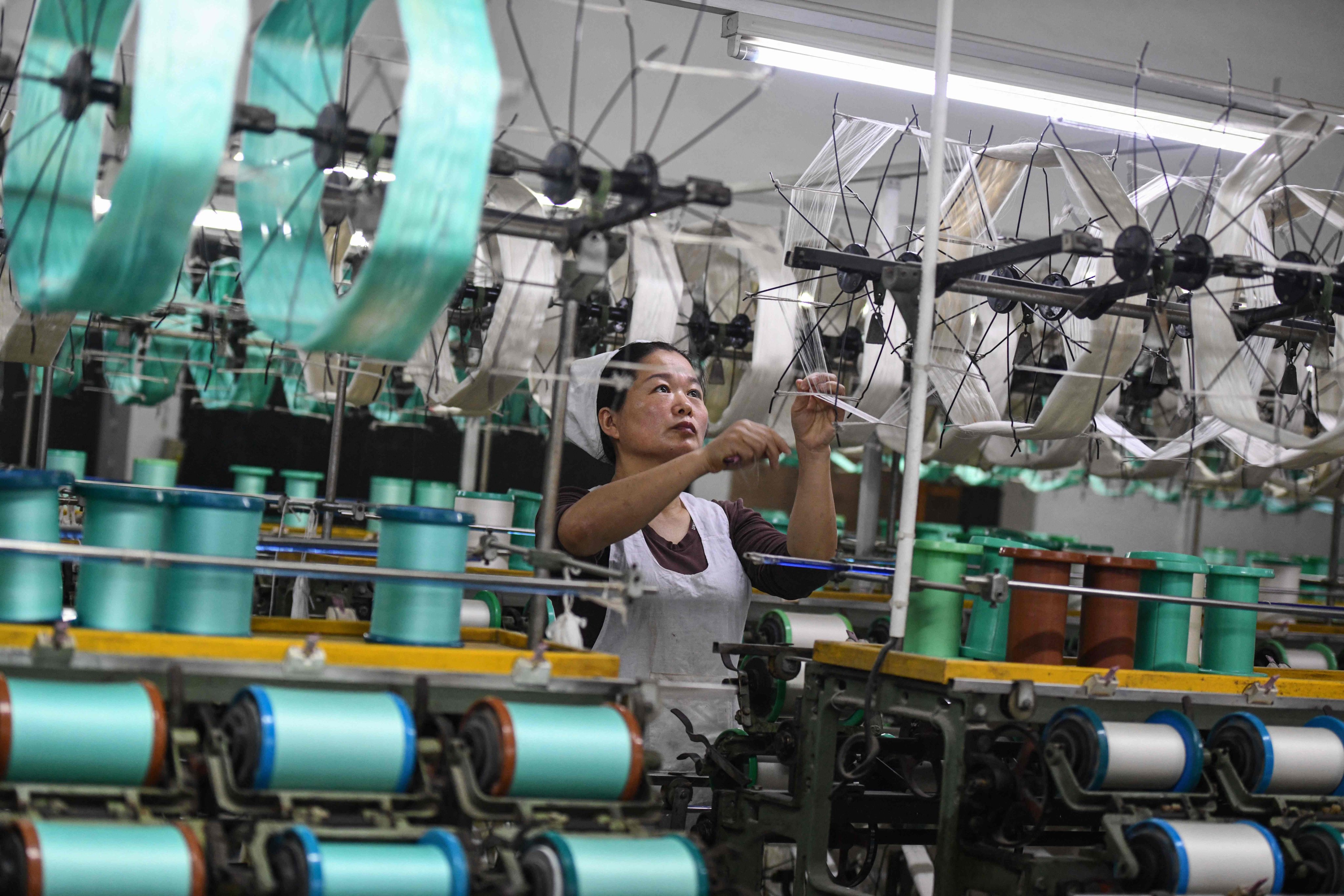 An employee works a textile factory that produces silk products in Fuyang in eastern China’s Anhui province. Photo: AFP