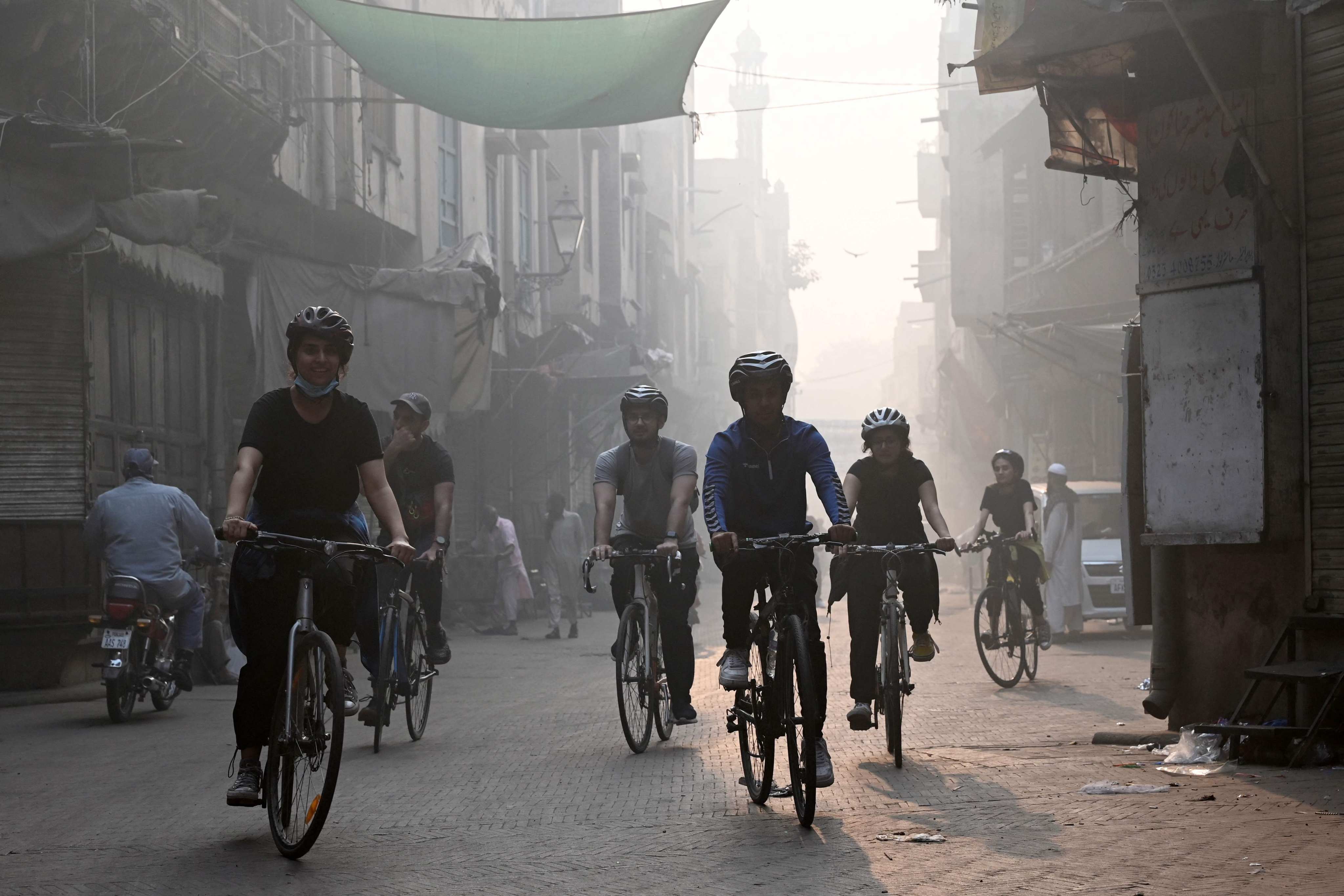 Cyclists ride along a street as they participate in an awareness campaign against smog and pollution in Lahore on Sunday. Photo: AFP