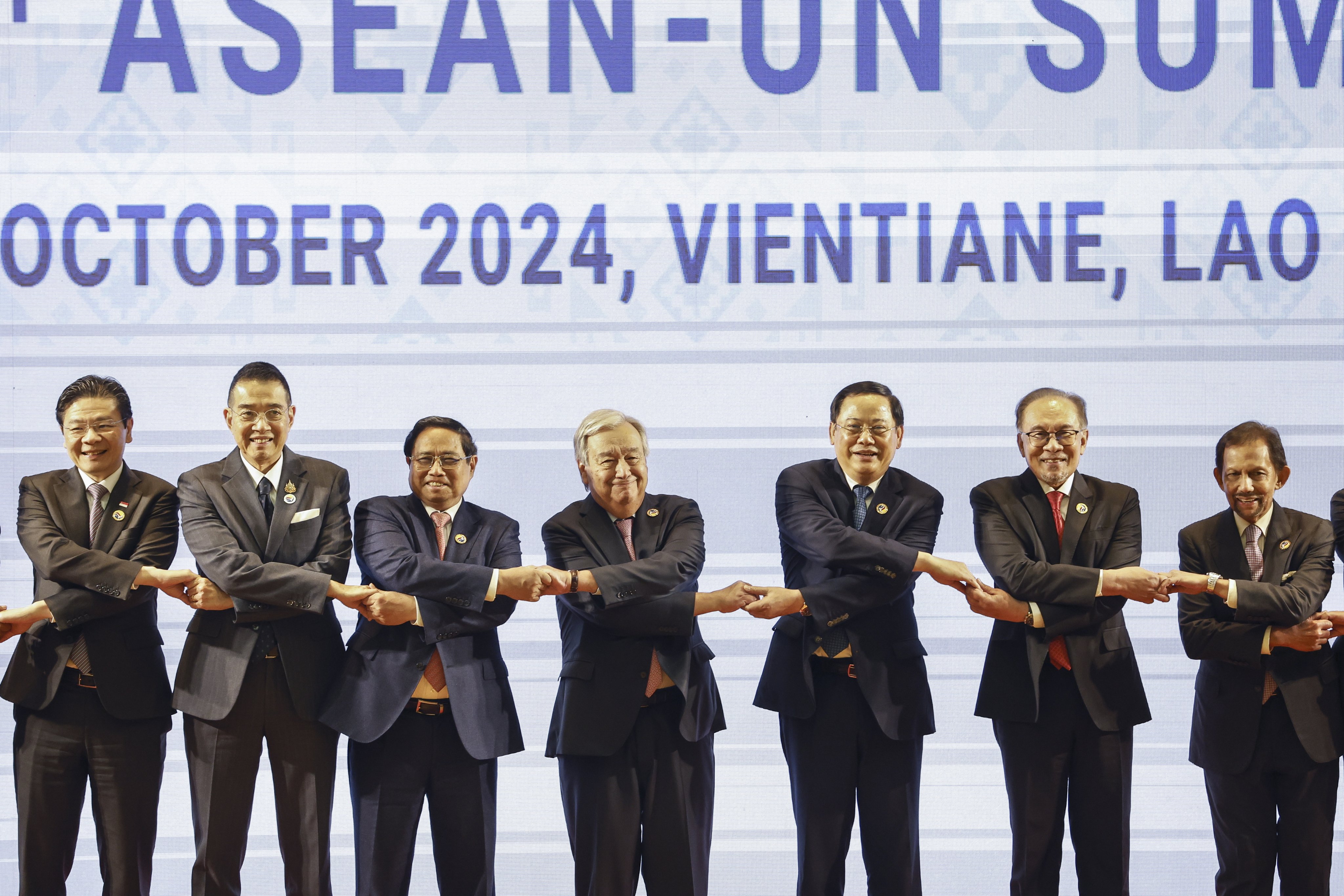 Singaporean Prime Minister Lawrence Wong, Thai Minister of Foreign Affairs Maris Sangiampongsa, Vietnamese Prime Minister Pham Minh Chinh, UN Secretary-General Antonio Guterres, Laotian Prime Minister Sonexay Siphandone, Malaysian Prime Minister Anwar Ibrahim and Brunei’s Sultan Hassanal Bolkiah hold hands during a “family photo” at the 14th Asean-United Nations Summit in Vientiane, Laos, on October 11. Photo: EPA-EFE