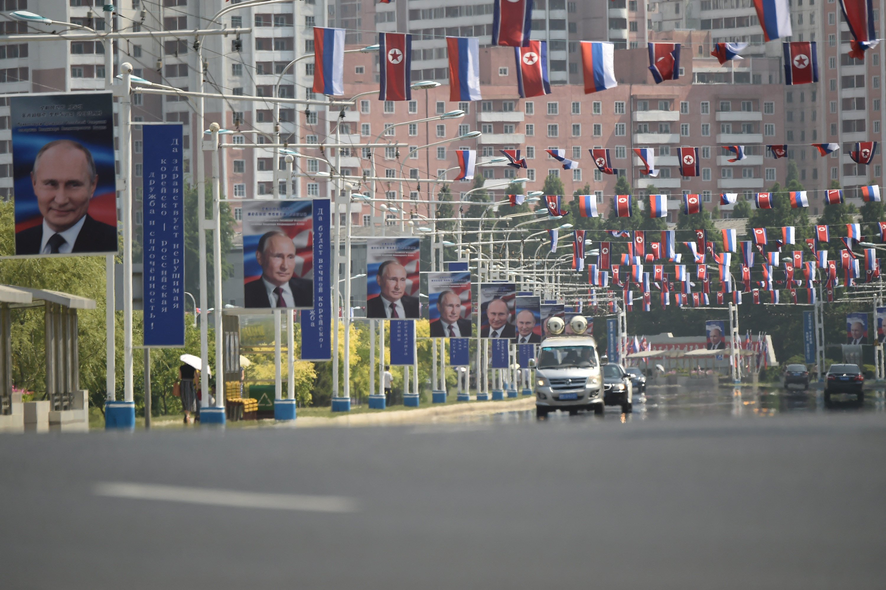 Portraits of Russian President Vladimir Putin are seen near national flags of North Korea and Russia in Pyongyang in June. Photo: TNS