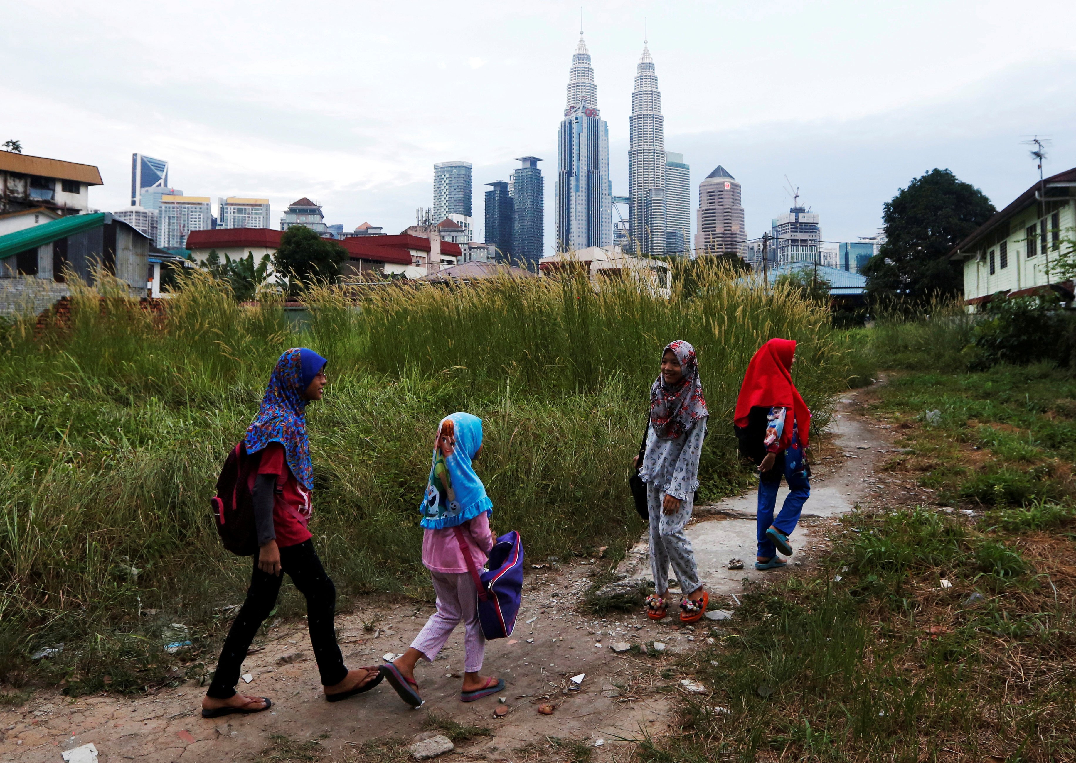 Girls make their way home after school in Kuala Lumpur, Malaysia. Photo: Reuters