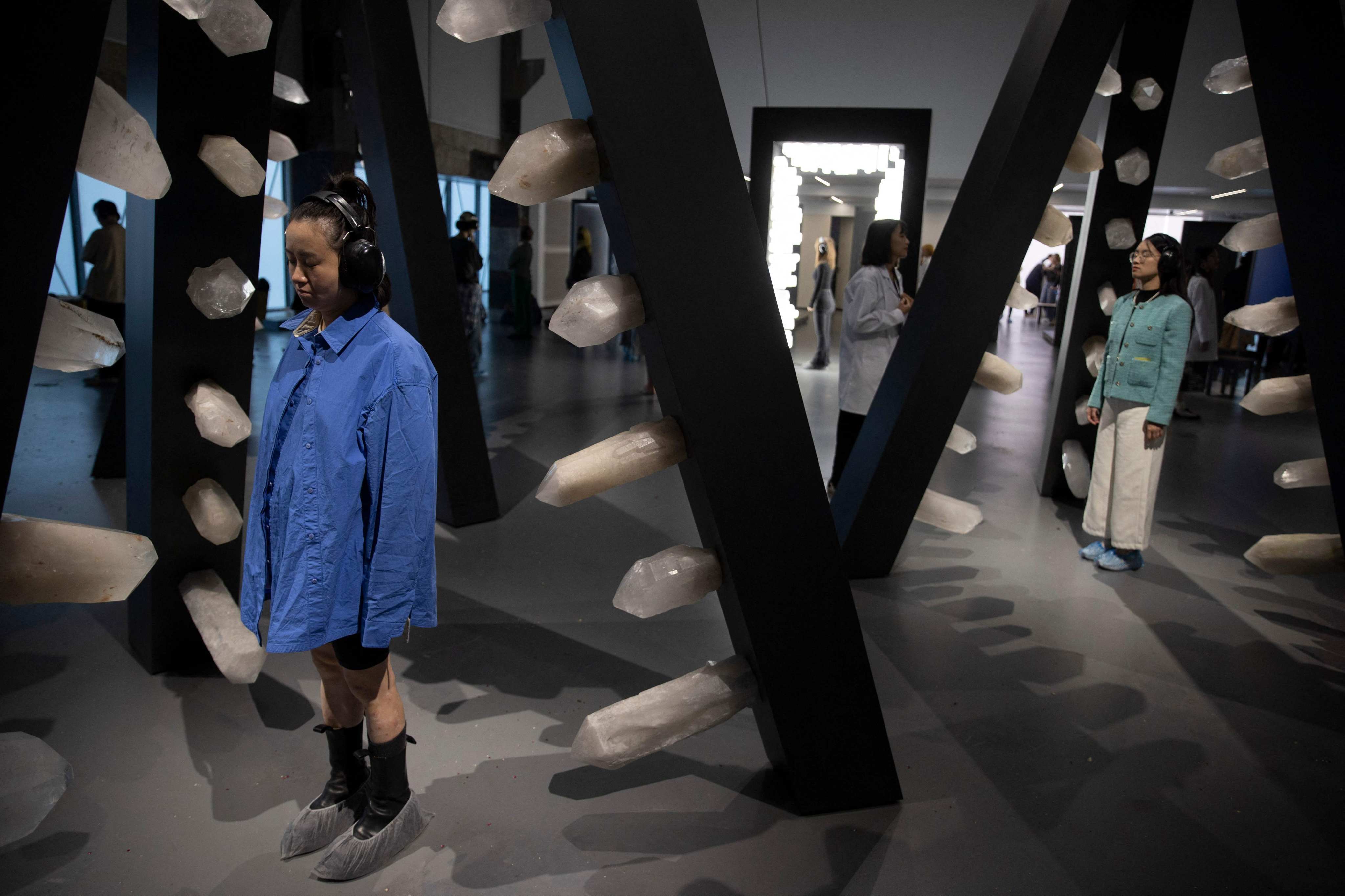 Visitors stand in an interactive artwork embedded with crystals, by Serbian conceptual artist Marina Abramovic, on the opening day of her first exhibition in China - titled “Transforming Energy�- in Shanghai on October 11, 2024. (Photo by AFP) / China OUT