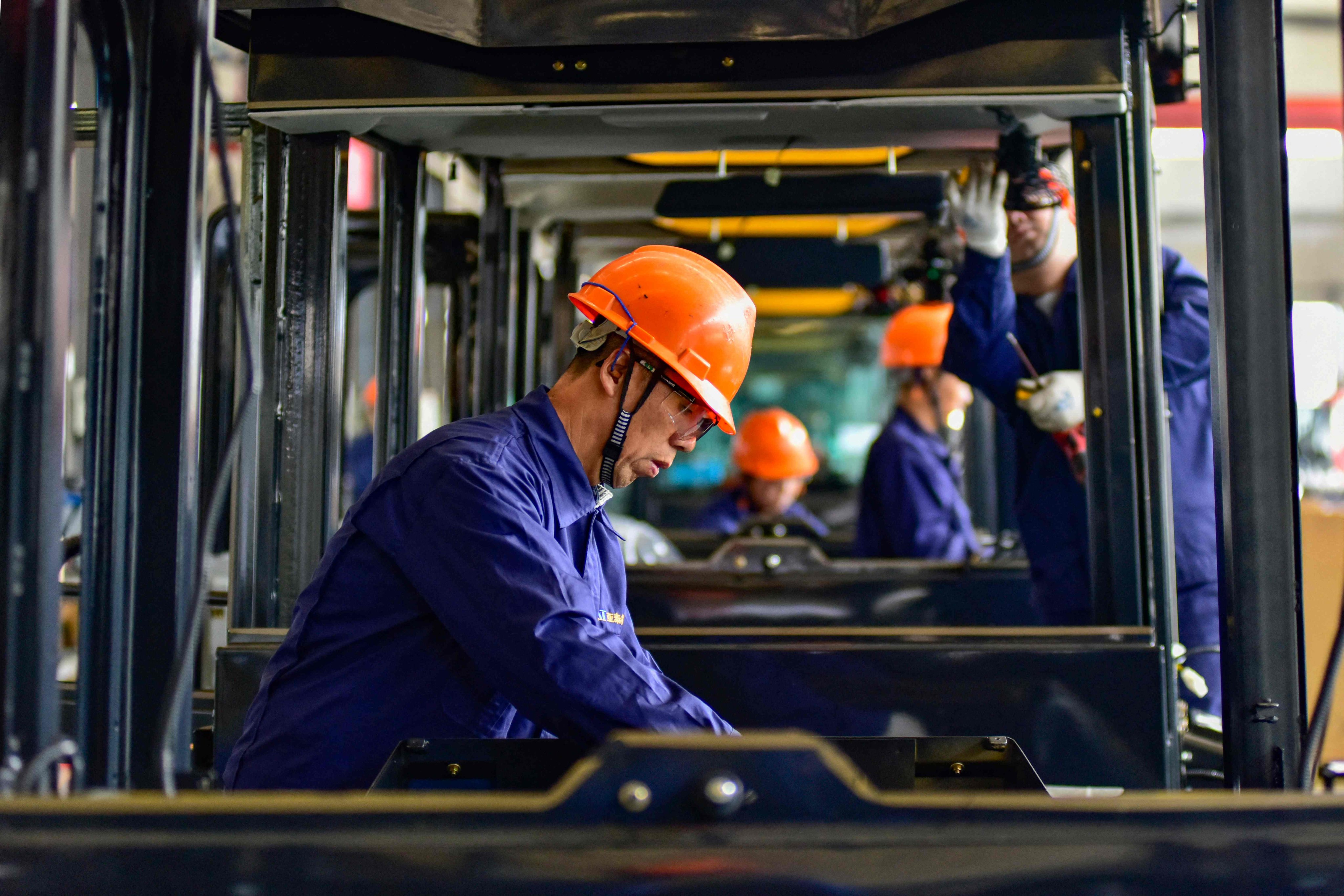 Workers build cabs for excavators at a factory in Qingzhou, in China’s eastern Shandong province. Photo: AFP