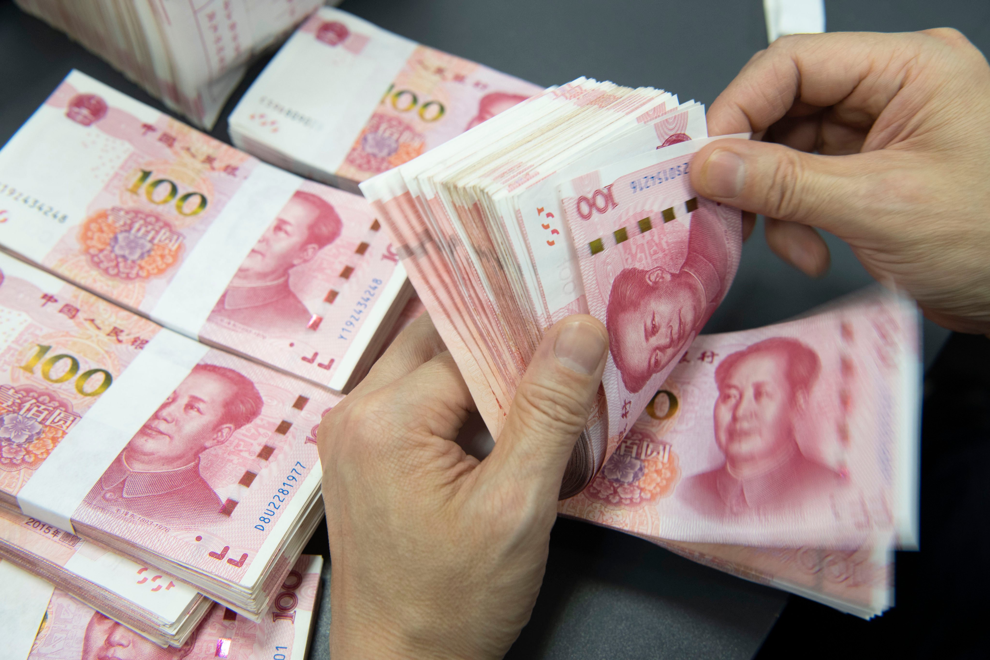 A bank employee counting Chinese yuan in Haian, Jiangsu province. Photo: NurPhoto via Getty Images