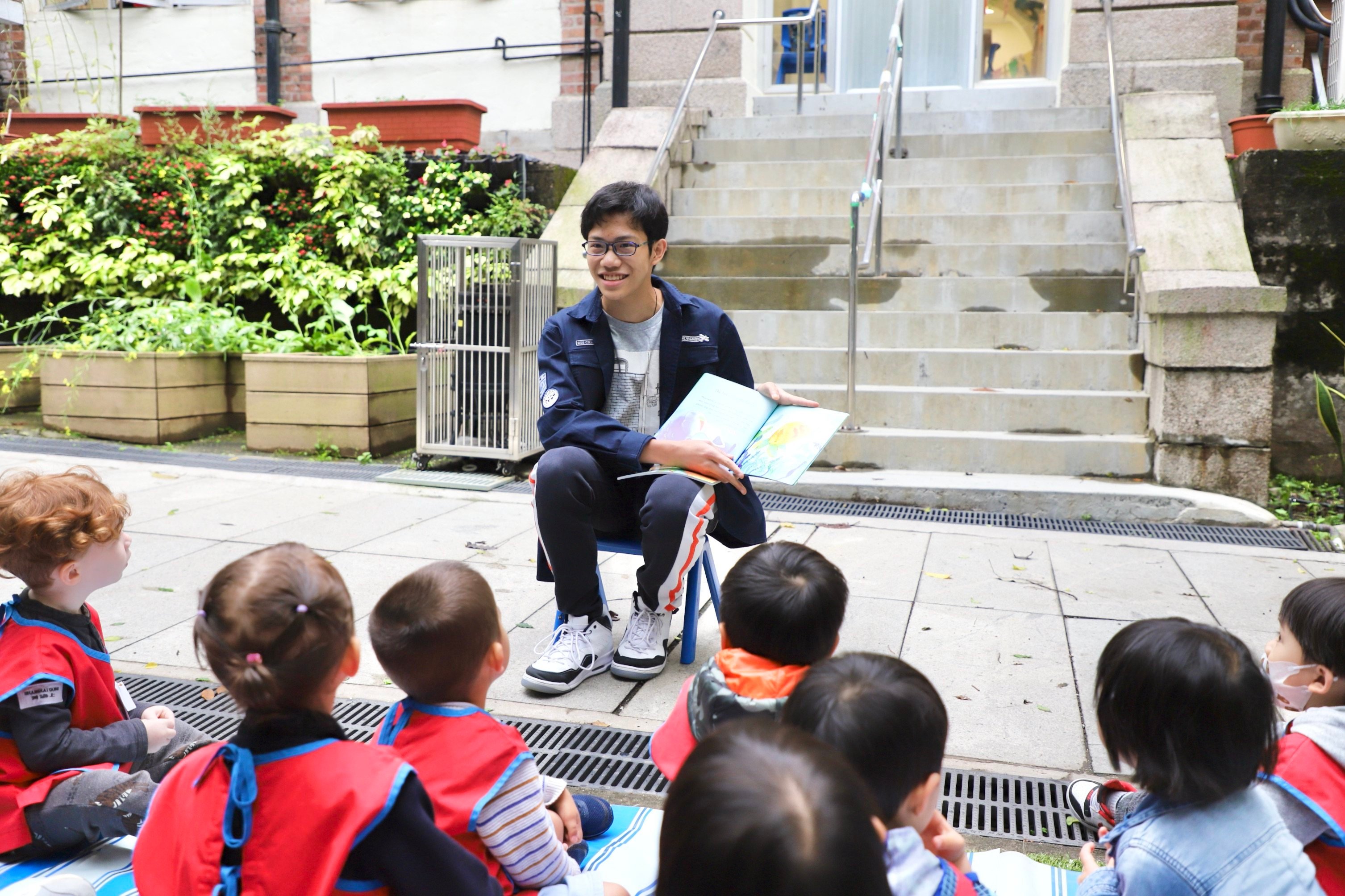 Kan King-lun reads to young students at Small World Christian Kindergarten. Photo: Handout