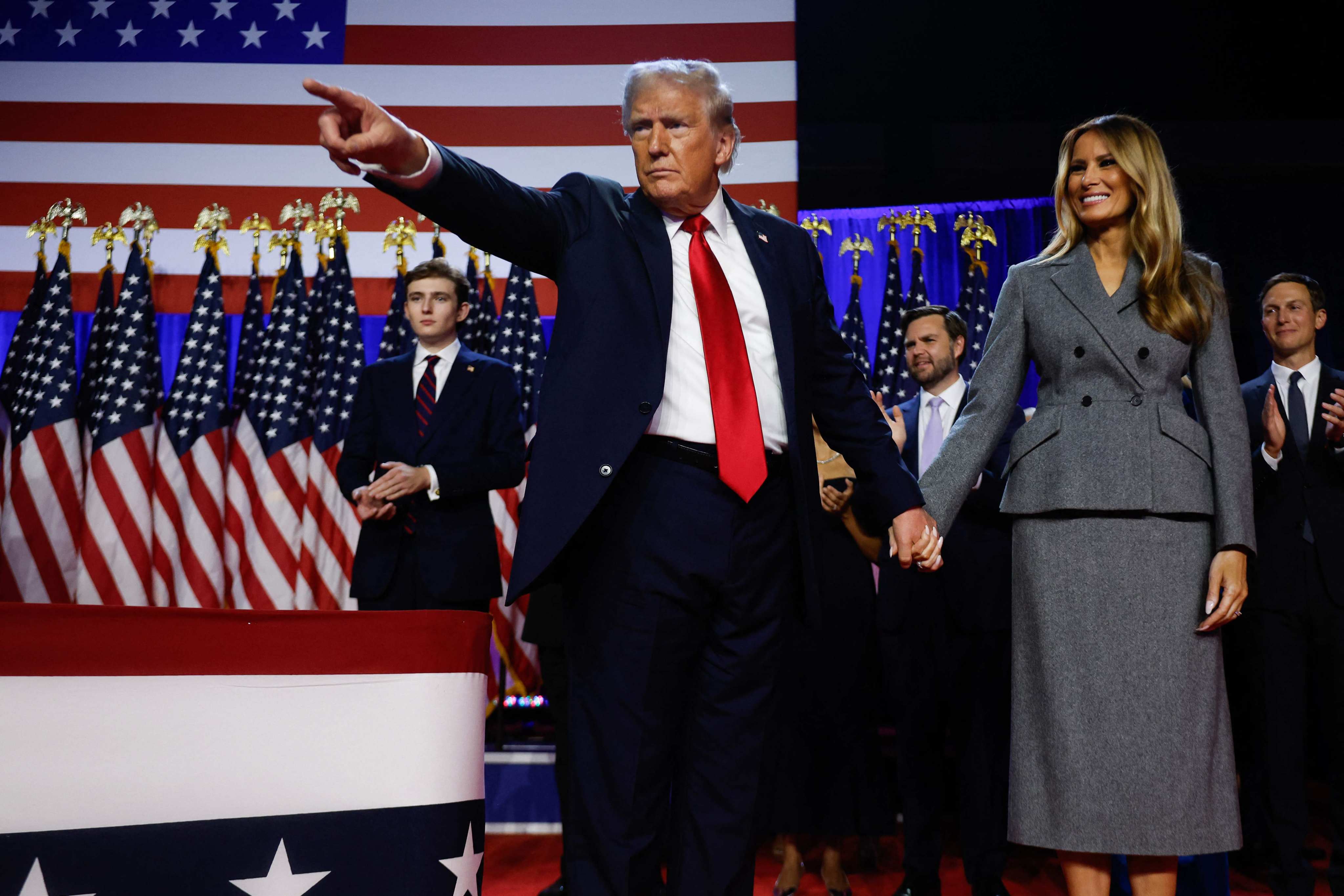 US president-elect Donald Trump points to supporters alongside his wife Melania during an election night event in West Palm Beach, Florida. Photo: Getty