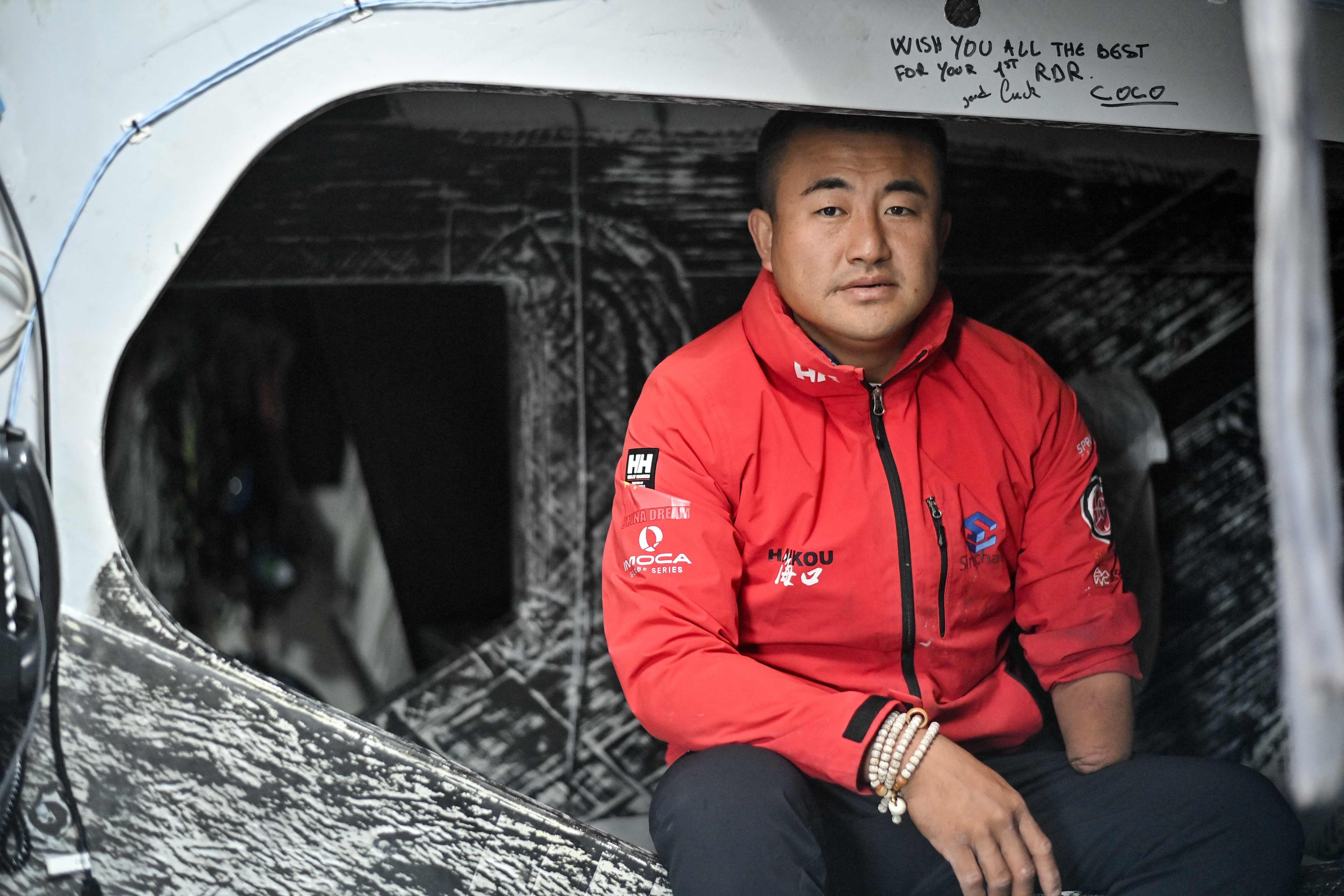 Chinese skipper Jingkun Xu poses for a picture aboard his Imoca monohull ‘Singchaim Team Hikou’ before the 10th edition of the Vendee Globe. Photo: AFP