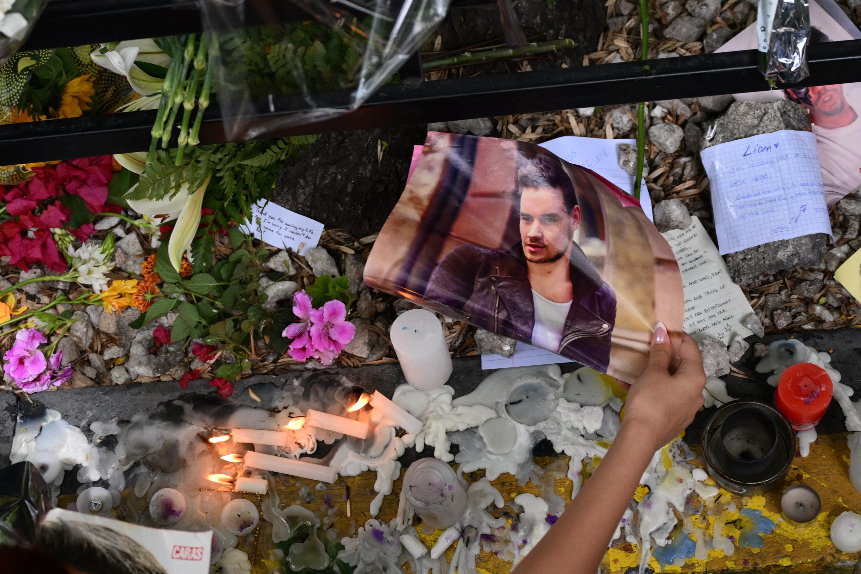 A fan pays tribute to One Direction member Liam Payne in front of the hotel where he died in Buenos Aires, Argentina on October 17. Three people were charged in connection with his death on Thursday. Photo: AFP / Getty Images / TNS