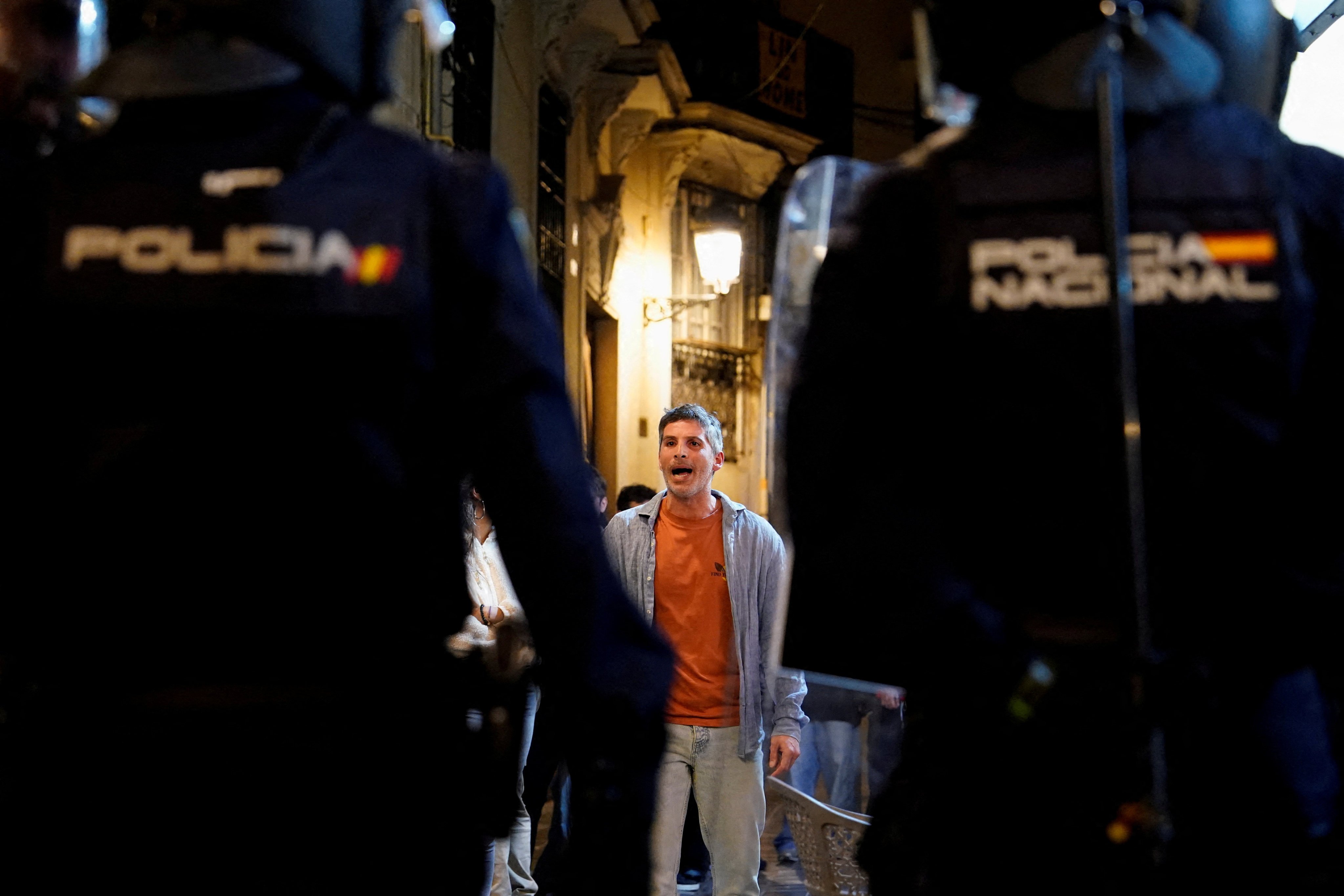 A demonstraror faces police officers as people protest against the management of the emergency response to the deadly floods in Valencia. Photo: Reuters