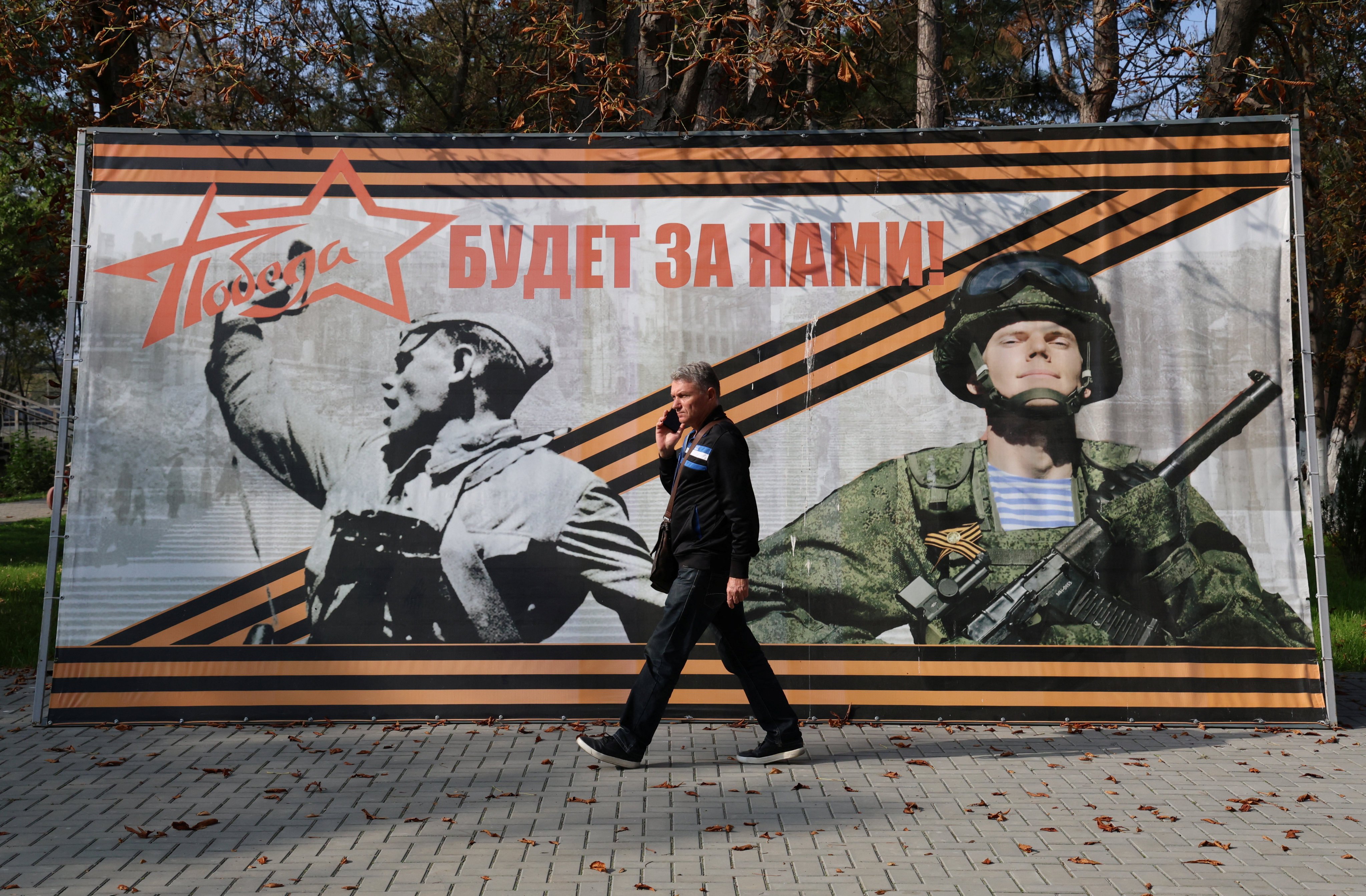 A man walks past a banner reading “Victory will be ours!” in the settlement of Sovetsky, Crimea, in October. Photo: Reuters