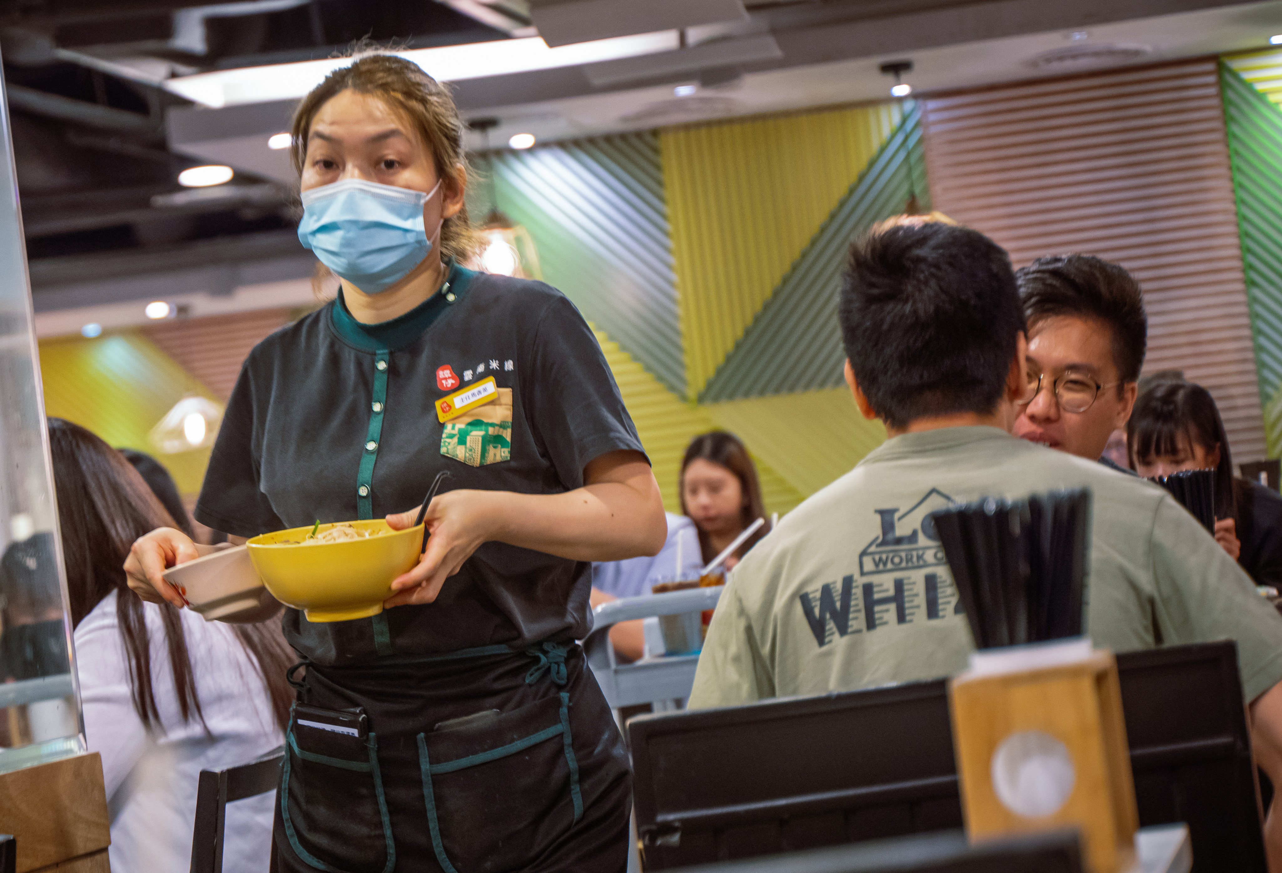 A female staff member carrying out a bowl of soup noodles at a Tam Jai restaurant in Causeway Bay, Hong Kong. Photo: Alexander Mak