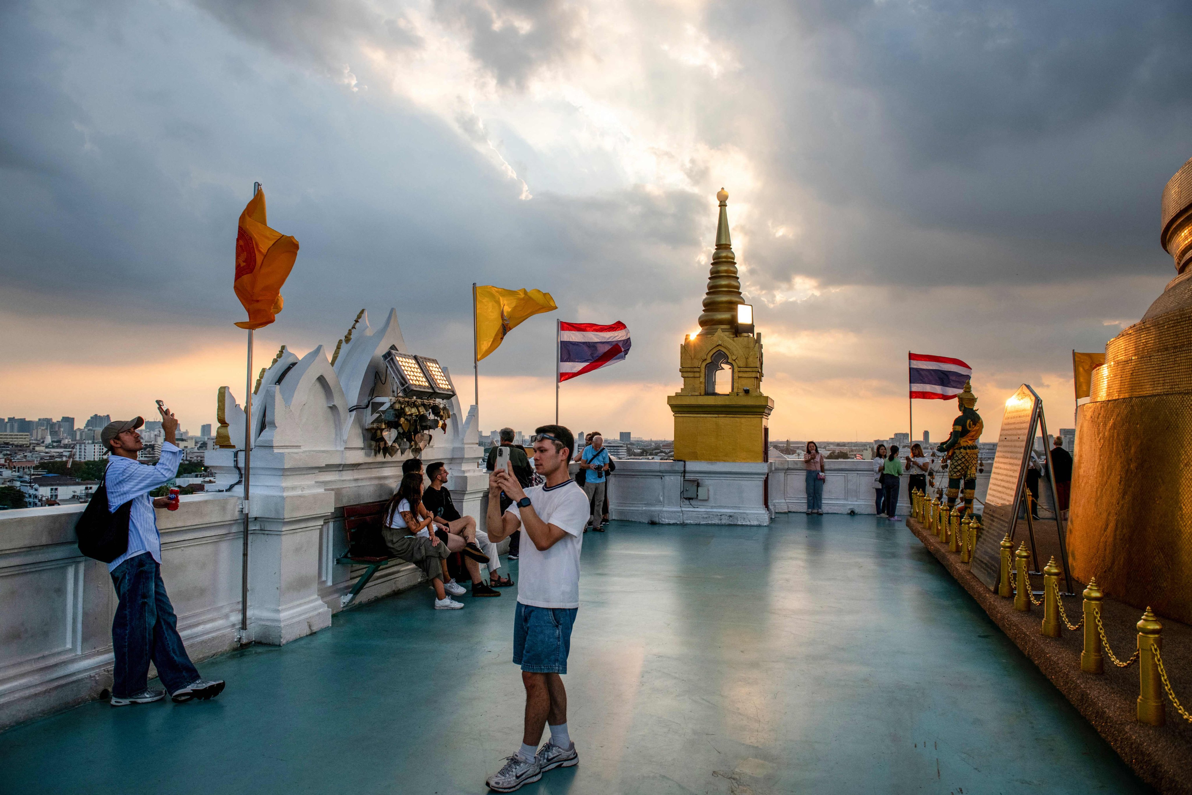 People visit the Golden Mount Temple at Wat Saket, an Ayutthaya-era Buddhist shrine, during sunset in Bangkok. Photo: AFP