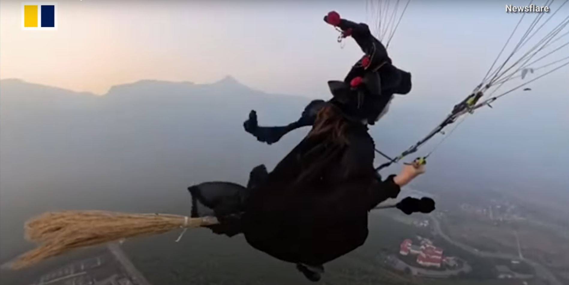 A woman went paragliding in central China’s Henan province dressed as a witch, complete with broomstick. Photo: Newsflare