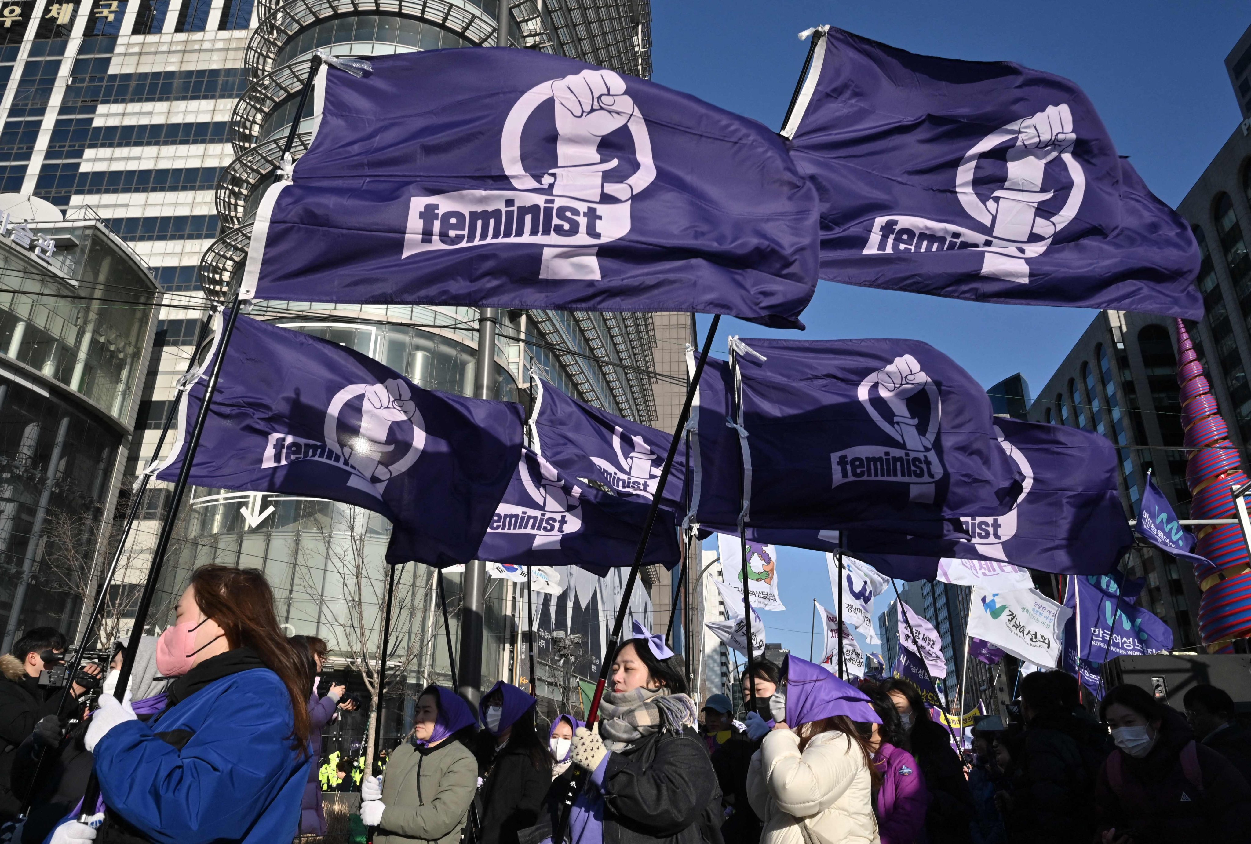 South Korean women carry flags reading “Feminist” on International Women’s Day in Seoul on March 8. South Korea’s feminist movement “4B” of no dating, sex, marriage or having children with men, has gone viral in America and beyond since Trump won the election. Photo: AFP