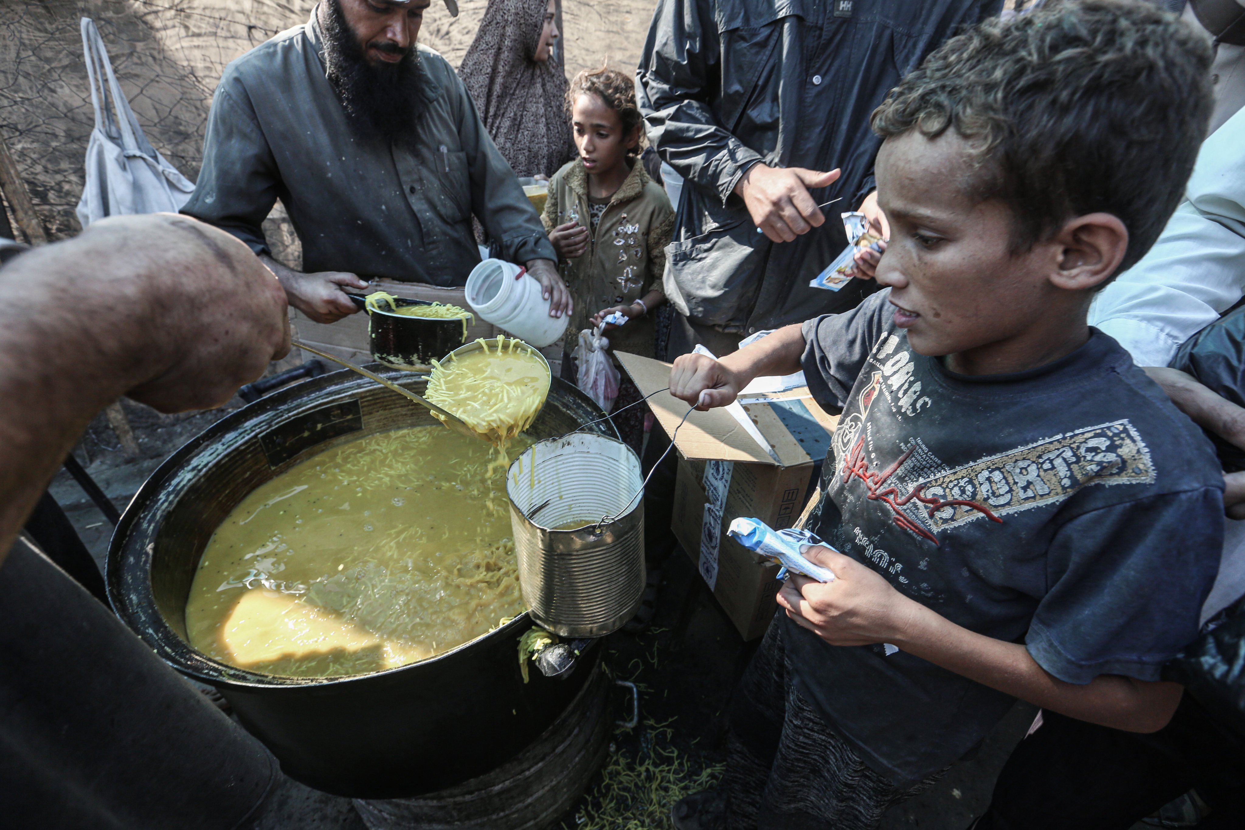 Palestinians children receive food distributed by an aid organization in Deir Al Balah. Photo: dpa