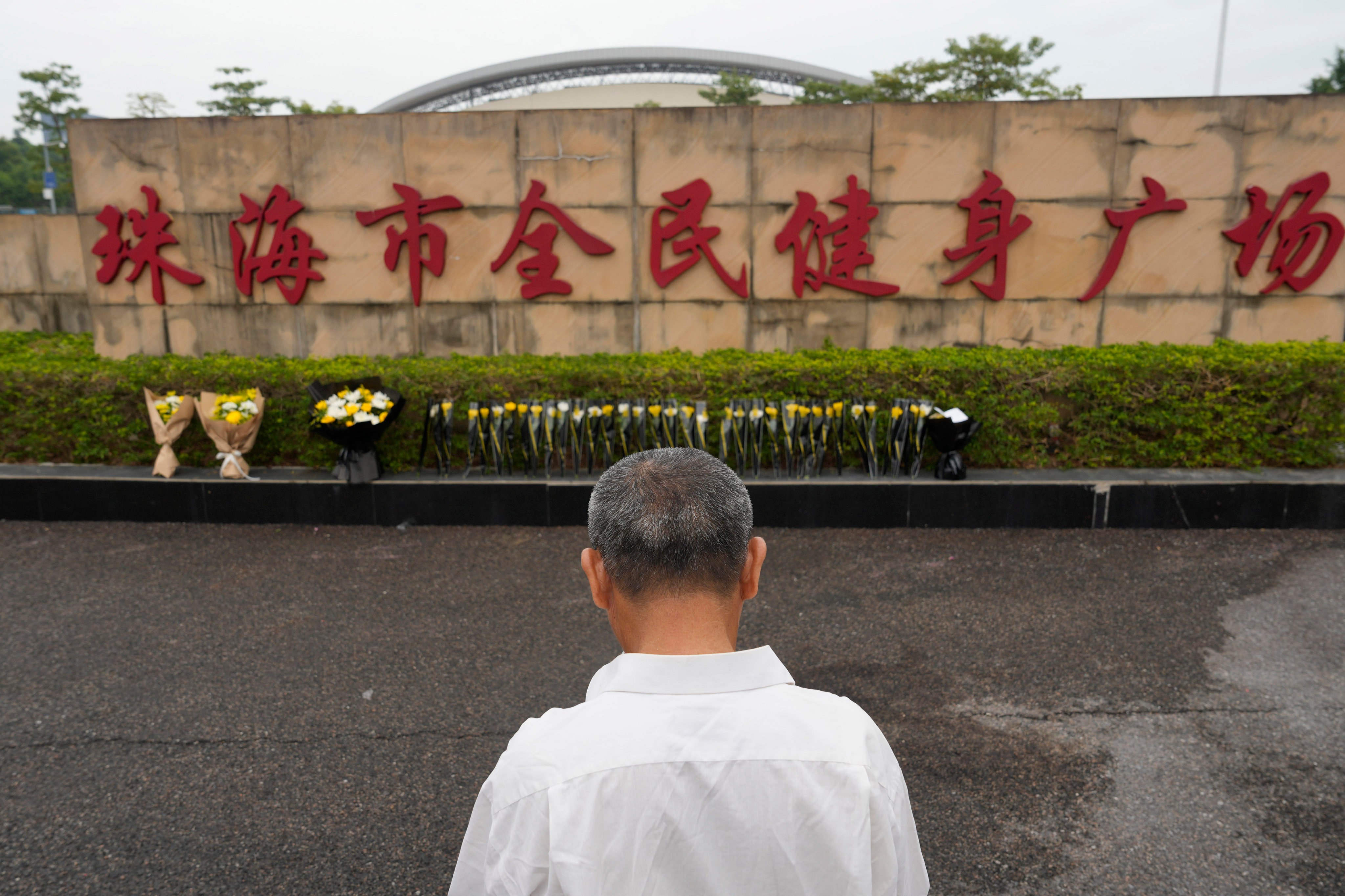 A local man looks at flowers laid outside the scene of the deadly attack in Zhuhai on Wednesday. Photo: AP 