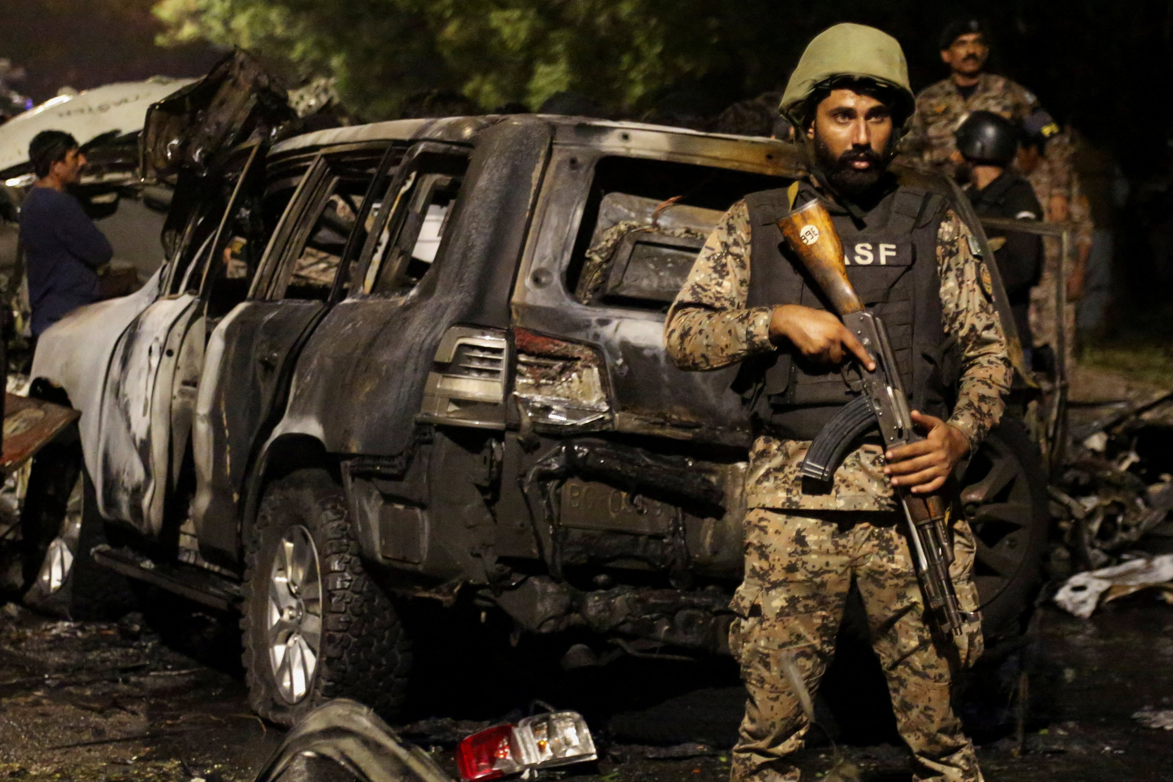 A member of the Airport Security Force ASF stands guard near the wreckage of vehicles after an explosion near Jinnah International Airport in Karachi, Pakistan on October 6. Photo: Reuters