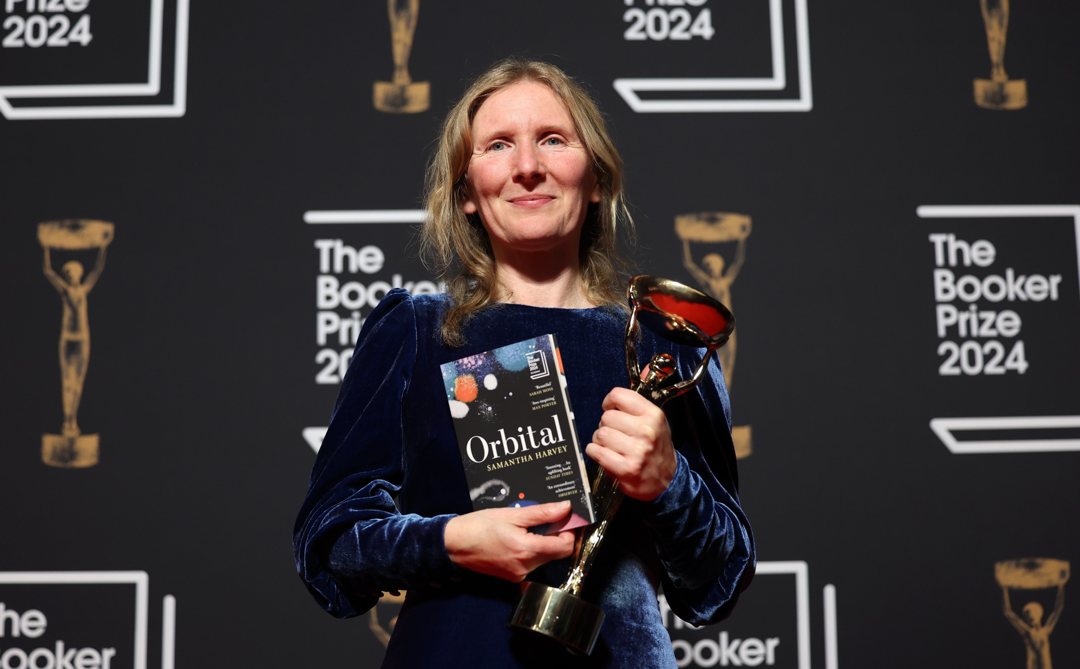 British novelist Samantha Harvey, author of the book “Orbital”, holds her trophy and a copy of her novel after winning the 2024 Booker Prize in London on Tuesday. Photo: EPA-EFE