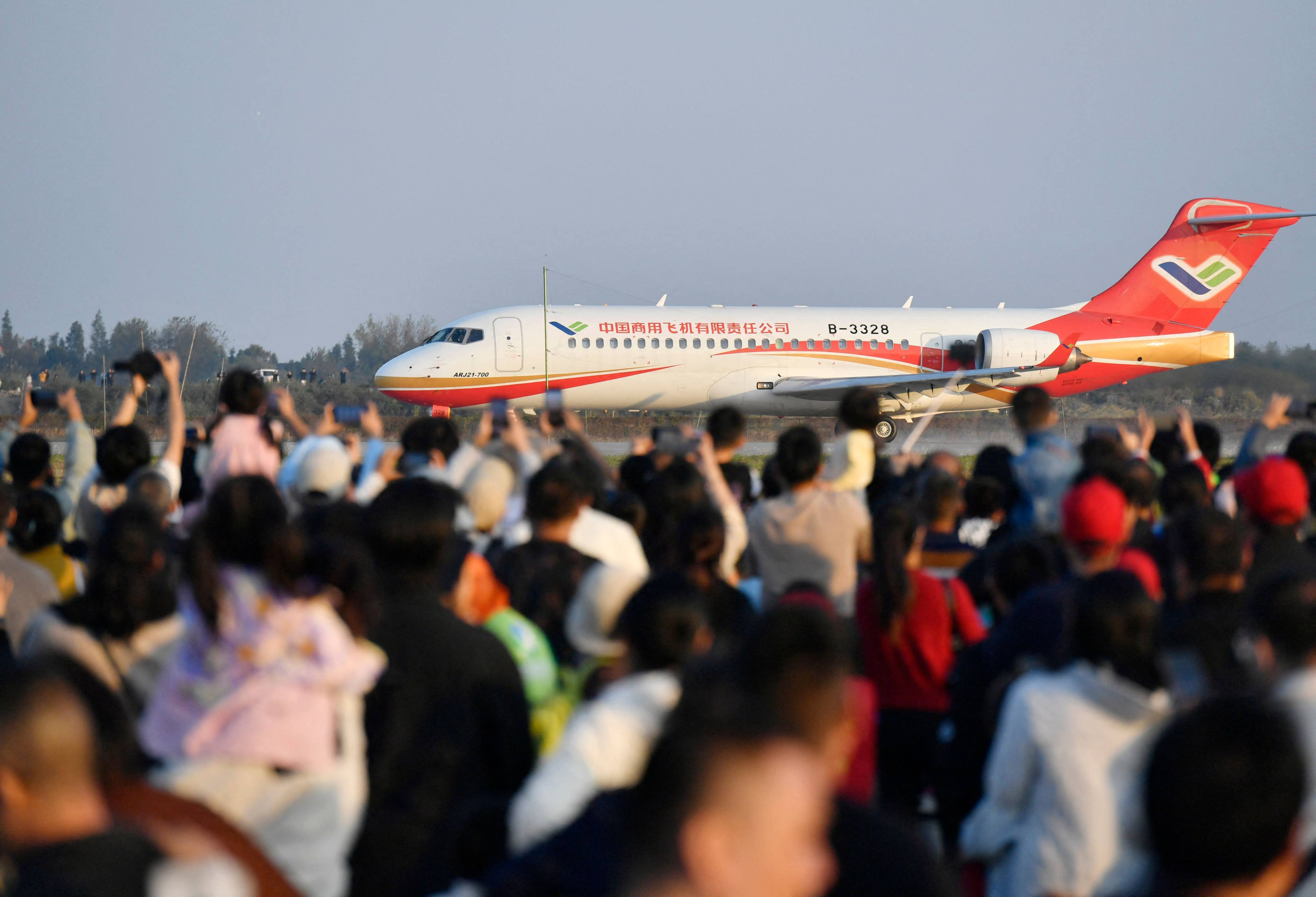 A crowd looks on as China’ss domestically produced C909 passenger jet lands at an air show in Nanchang in the central Jiangxi province. Photo: AFP