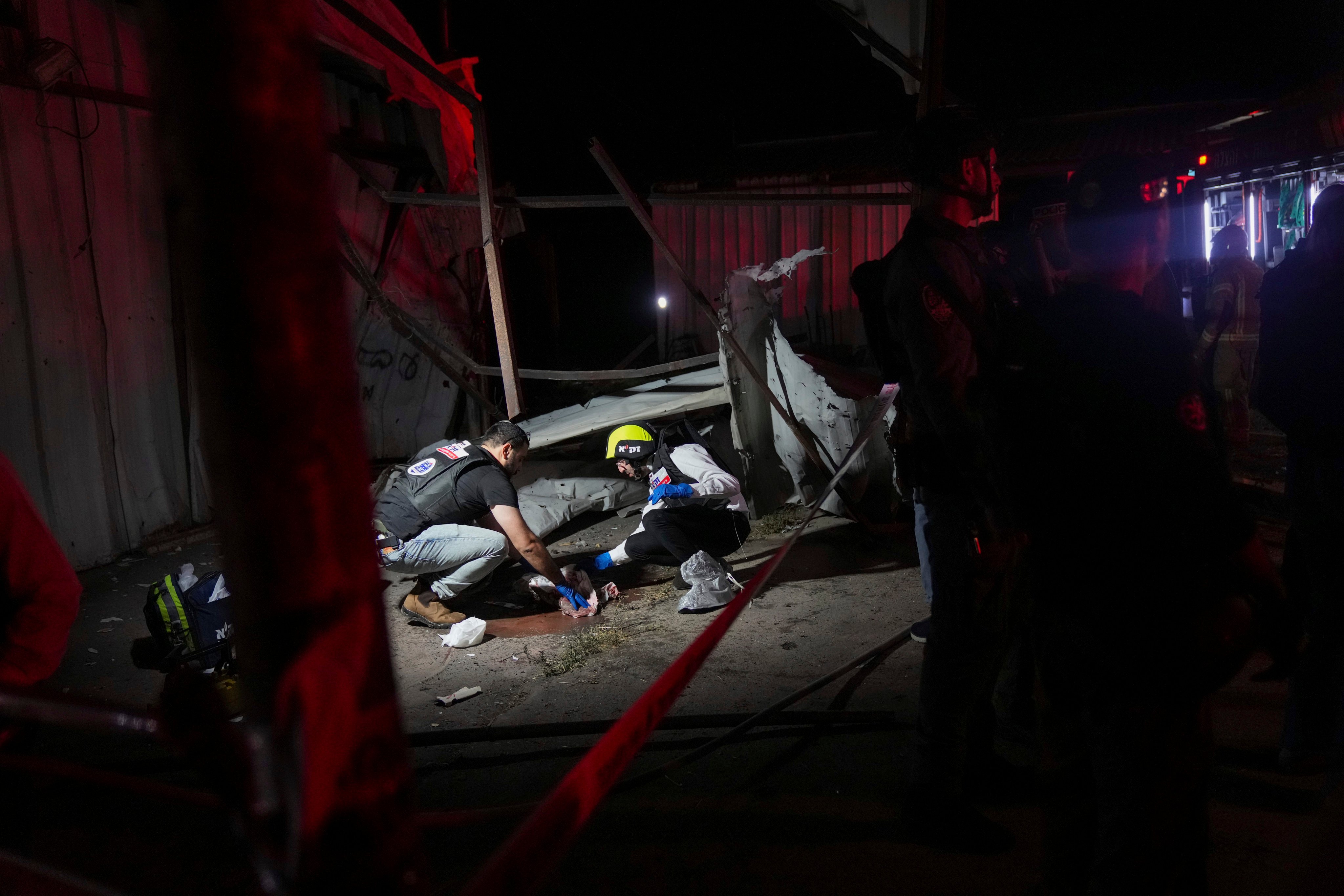 Members of ZAKA rescue services clean the blood stains where a rocket fired from Lebanon hit in the northern Israeli town of Nahariya, killing two. Photo: AP