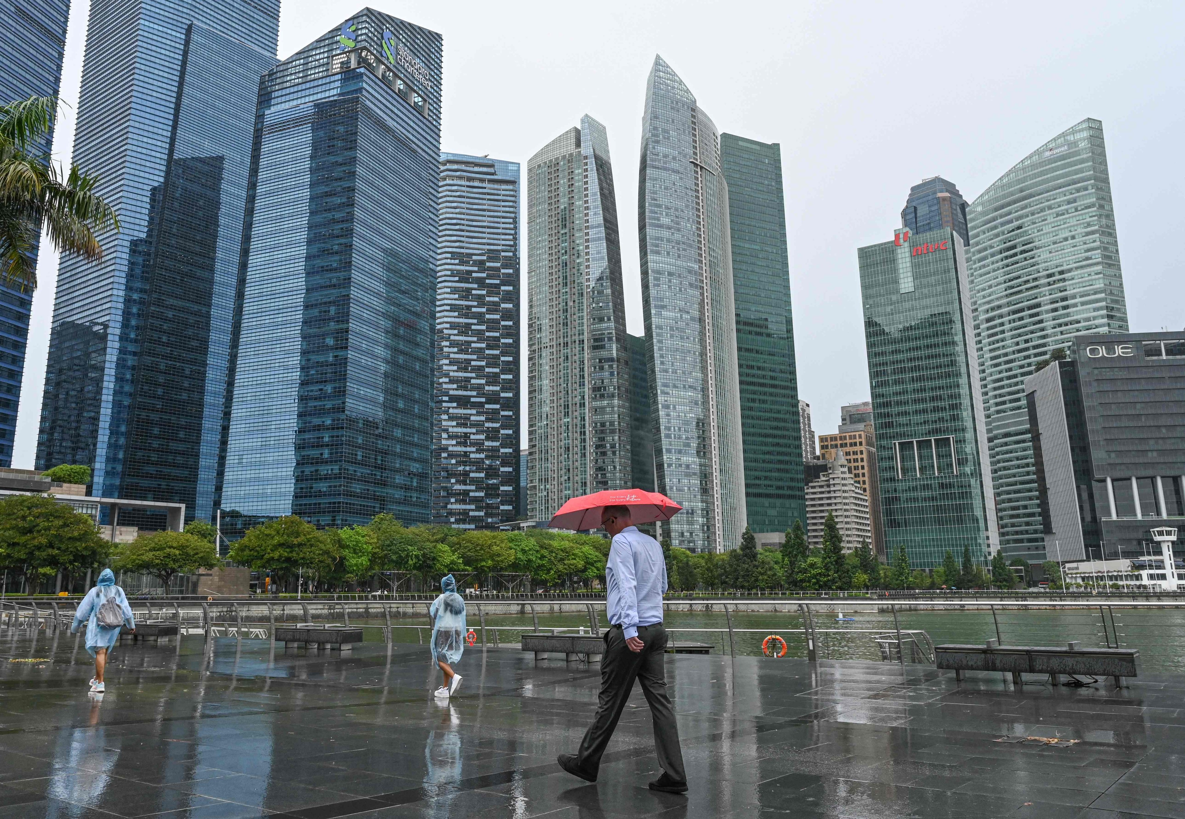 People walk along the promenade near the financial business district in Singapore. Photo: AFP