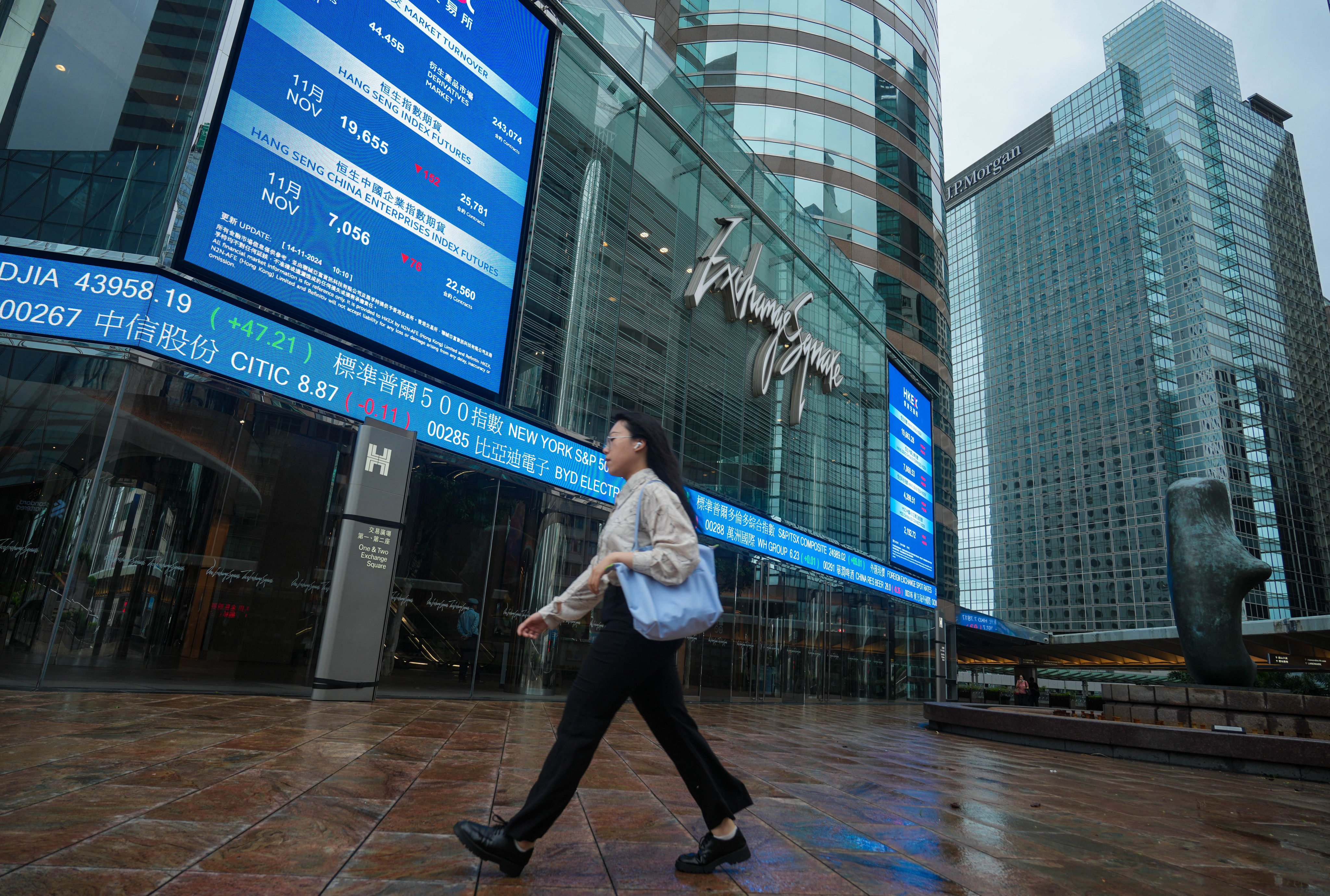 Pedestrians walk past Exchange Sqaure in Central under the Storm Signal No.8. Photo: Sam Tsang