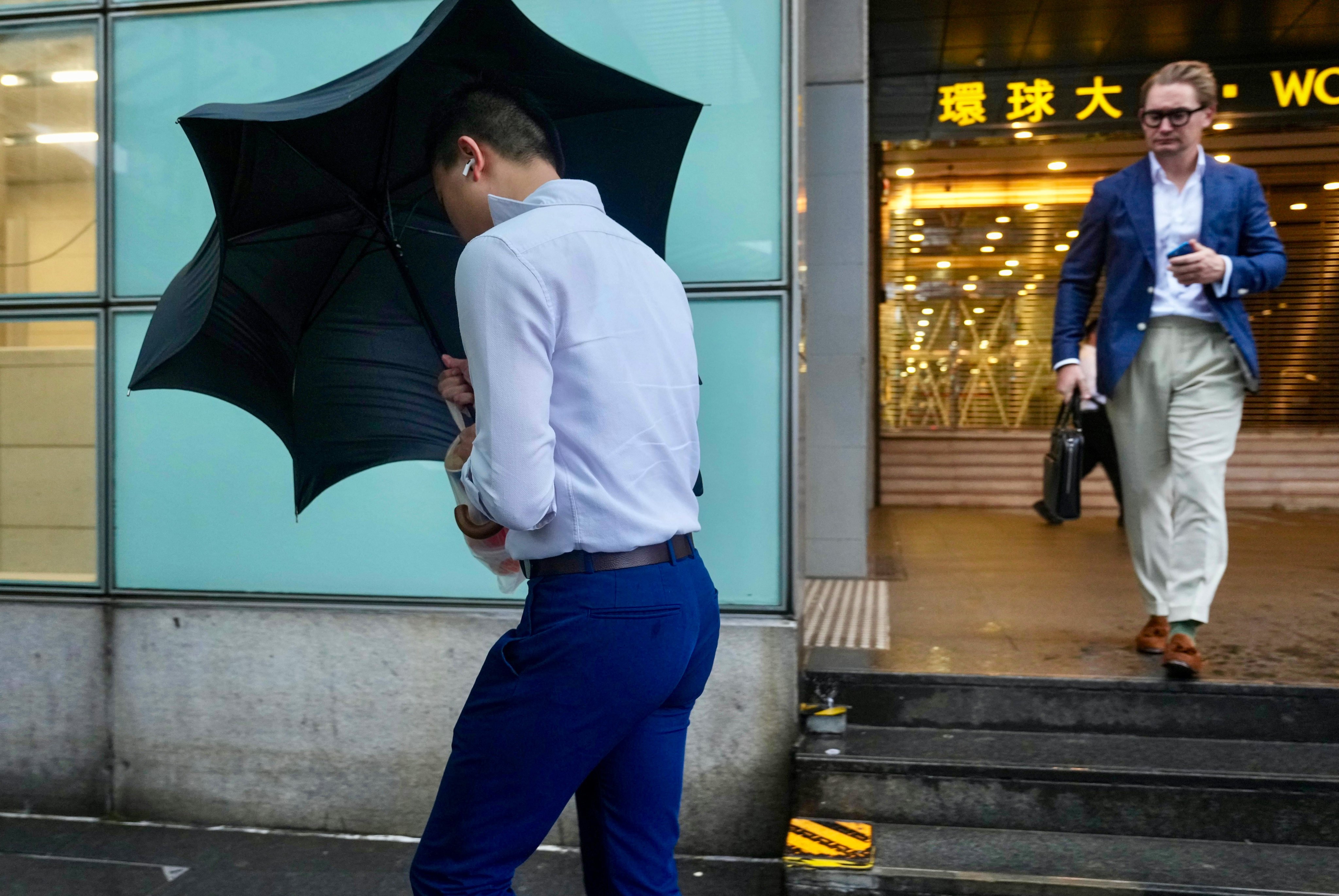 Pedestrians walk in Central under the Storm Signal No.8. Photo: Sam Tsang