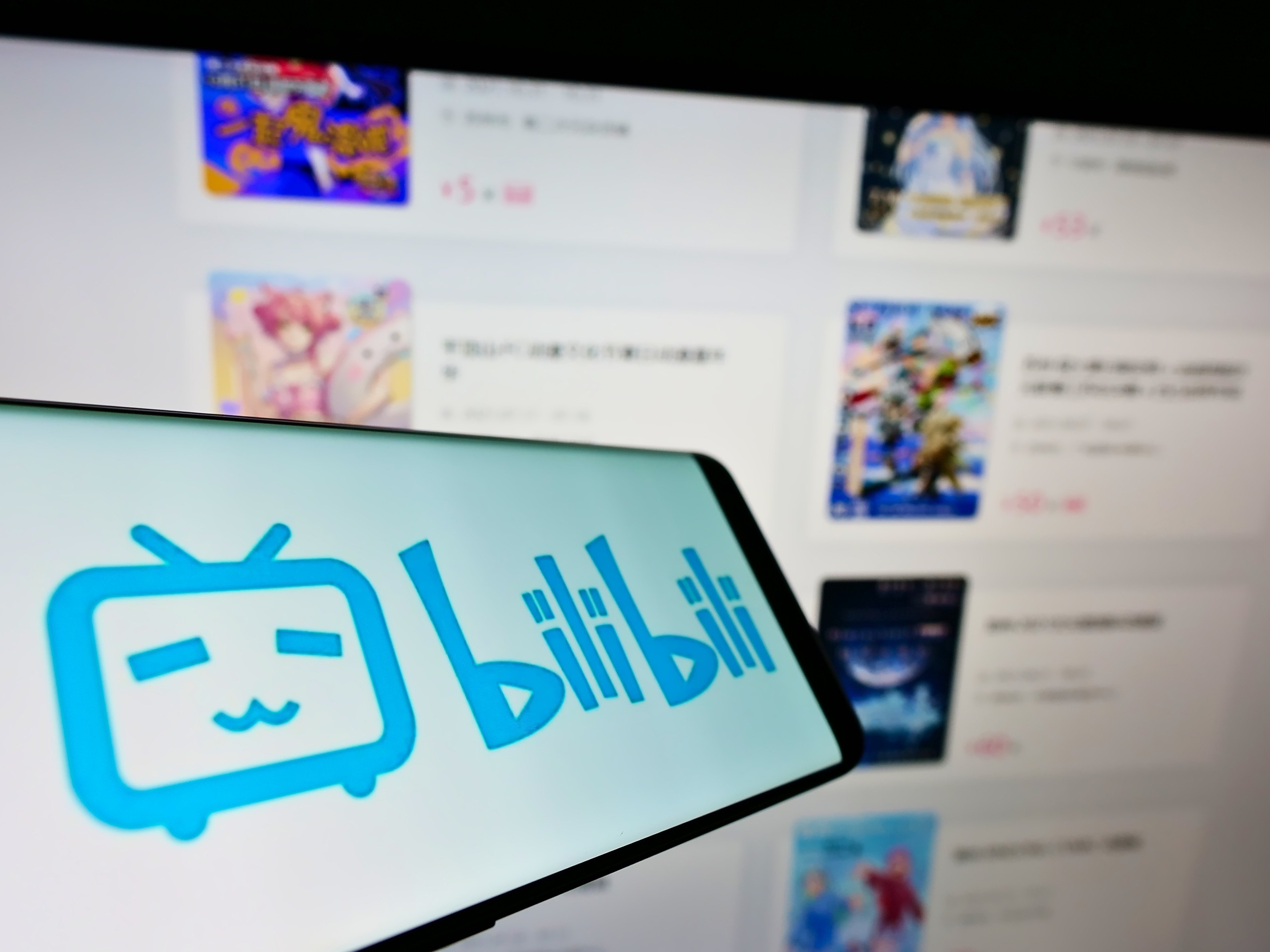 The Bilibili logo is displayed on a smartphone screen in front of the company’s website. Photo: Shutterstock Images
